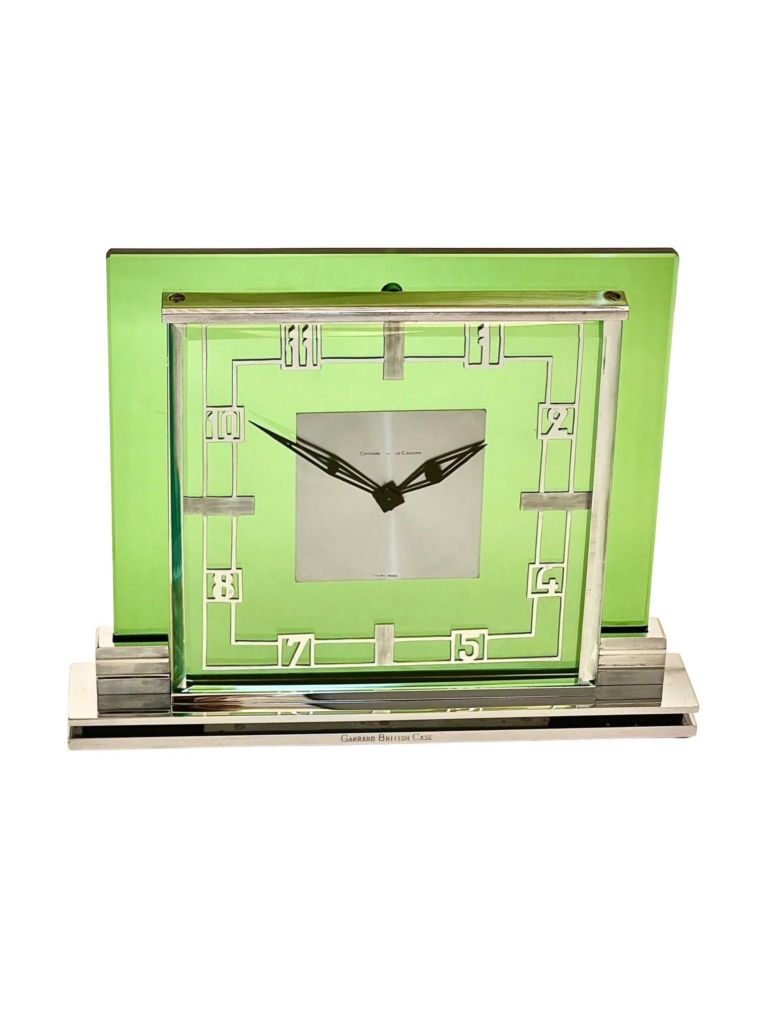 A beautiful and rare mid century chrome and emerald green glass eight day timepiece mantel clock by Jaeger LeCoultre, Switzerland. The case is by Garrard, London. Jaeger LeCoultre and Garrard are both well-known luxury brands with a long history of