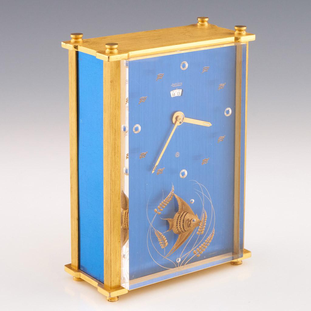 A midcentury Jaeger 24 hour musical alarm clock. Brass case with inset gilt fish swimming amongst the reeds. Wave pattern brass hour markers and gilt sword hands. Original 8 day movement. 

Dimensions: H 12cm W 9cm D 4cm

Origin: Swiss

Date: