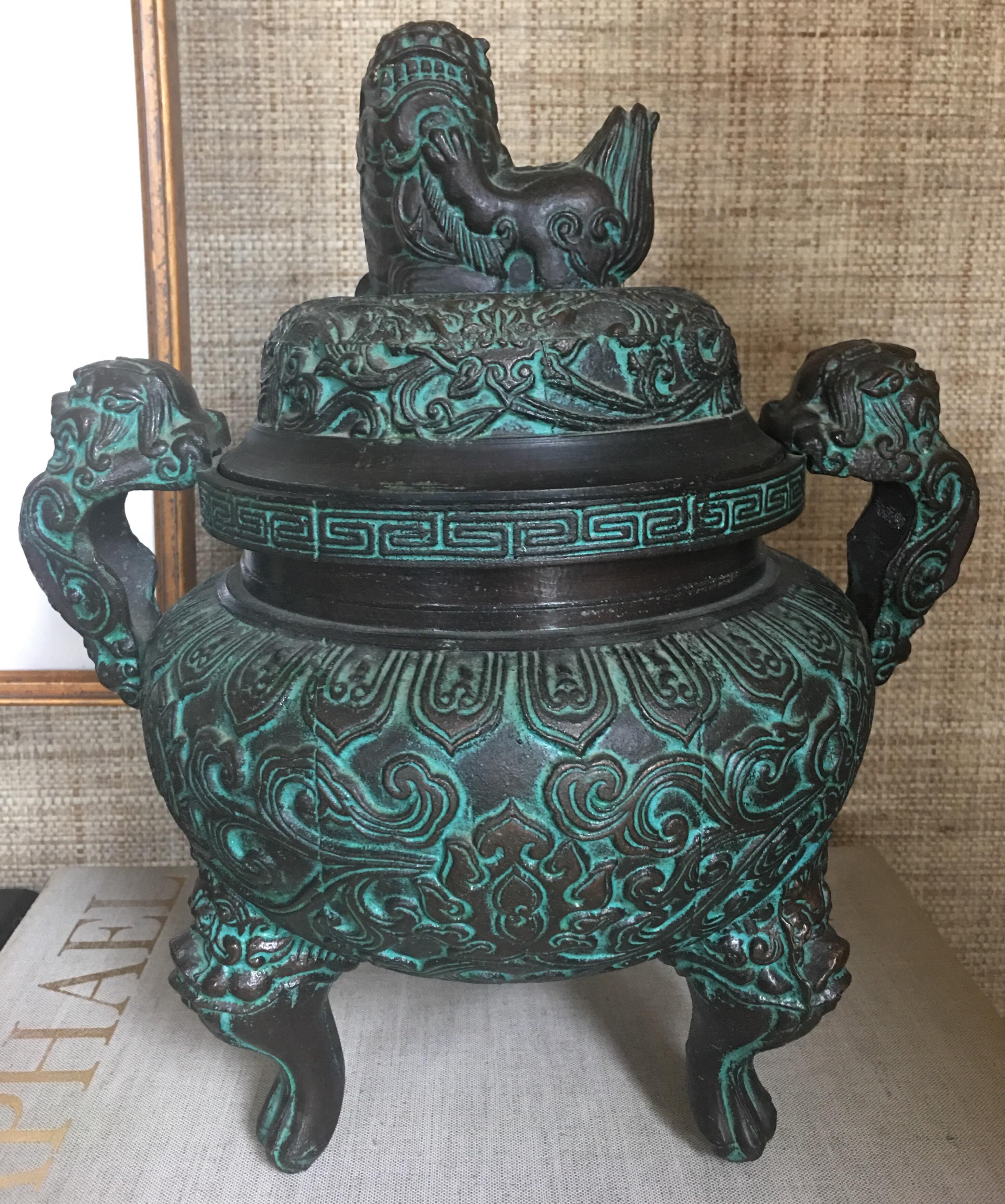 Midcentury modern era Asian style ice bucket in the manner of James Mont. This highly detailed metal piece features a faux bronze verdigrises’ finish and intricate geometric engraving and embossing. The interior is lined with a removable turquoise