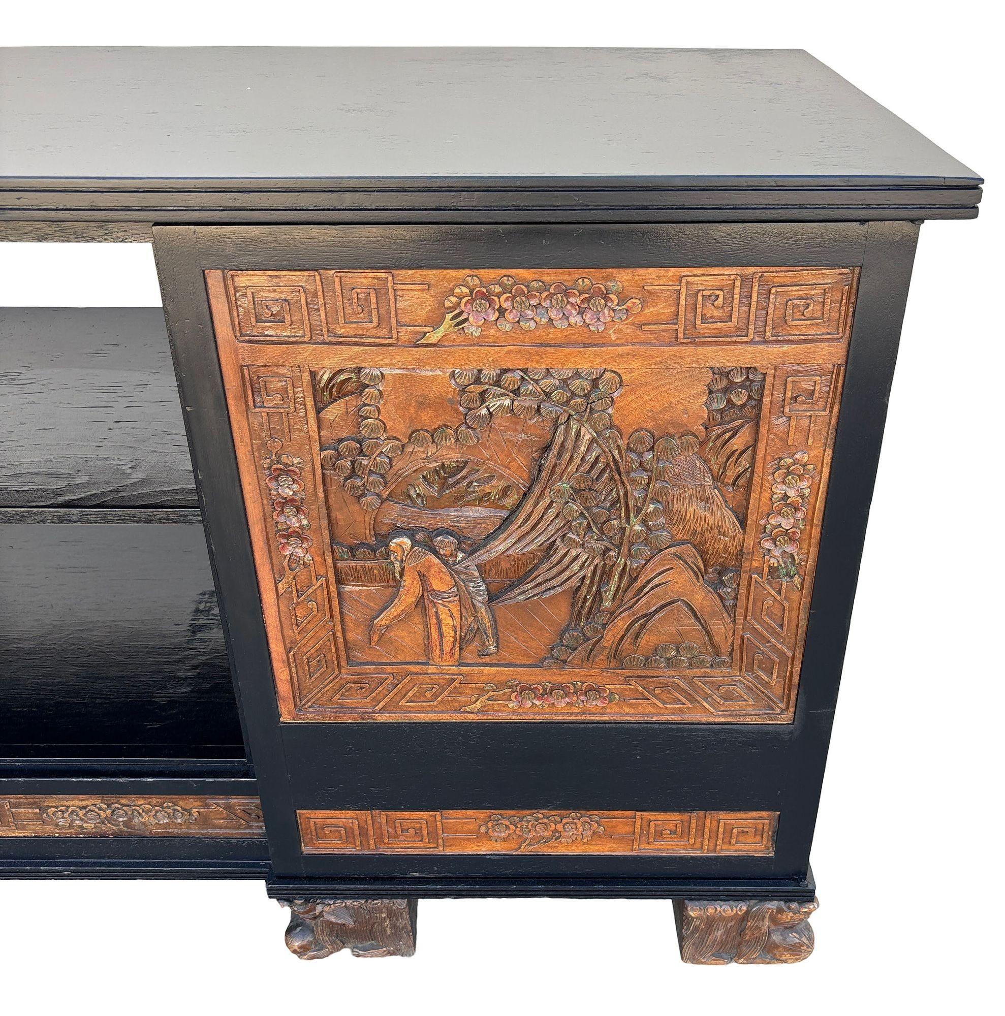 This beautifully restored Mid-century Credenza Media Console with hand-carved asian scenics along the front doors in the style of James Mont. The cabinet features a working AM Radio on the left side behind the left door. It has been meticulously