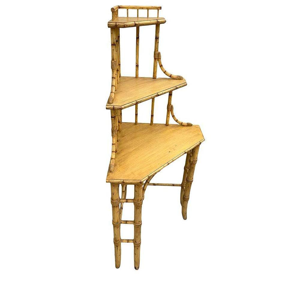 Scaffale ad angolo in bambù a tre livelli di ispirazione asiatica di James Mont con finitura in legno biondo che ne esalta l'estetica leggera e ariosa. Questo scaffale presenta linee eleganti e intricati rivestimenti in vimini con tre livelli che