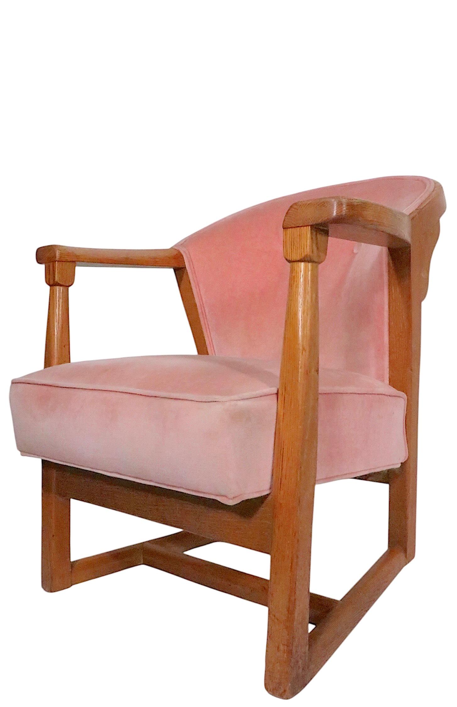 Rare mid century arm chair made by the Jamestown Lounge Company, as part of the sought after British Oak series, circa 1930/40's. The chair features an exposed solid oak frame, with sculpted arm rests. The seat and back are upholstered in pink