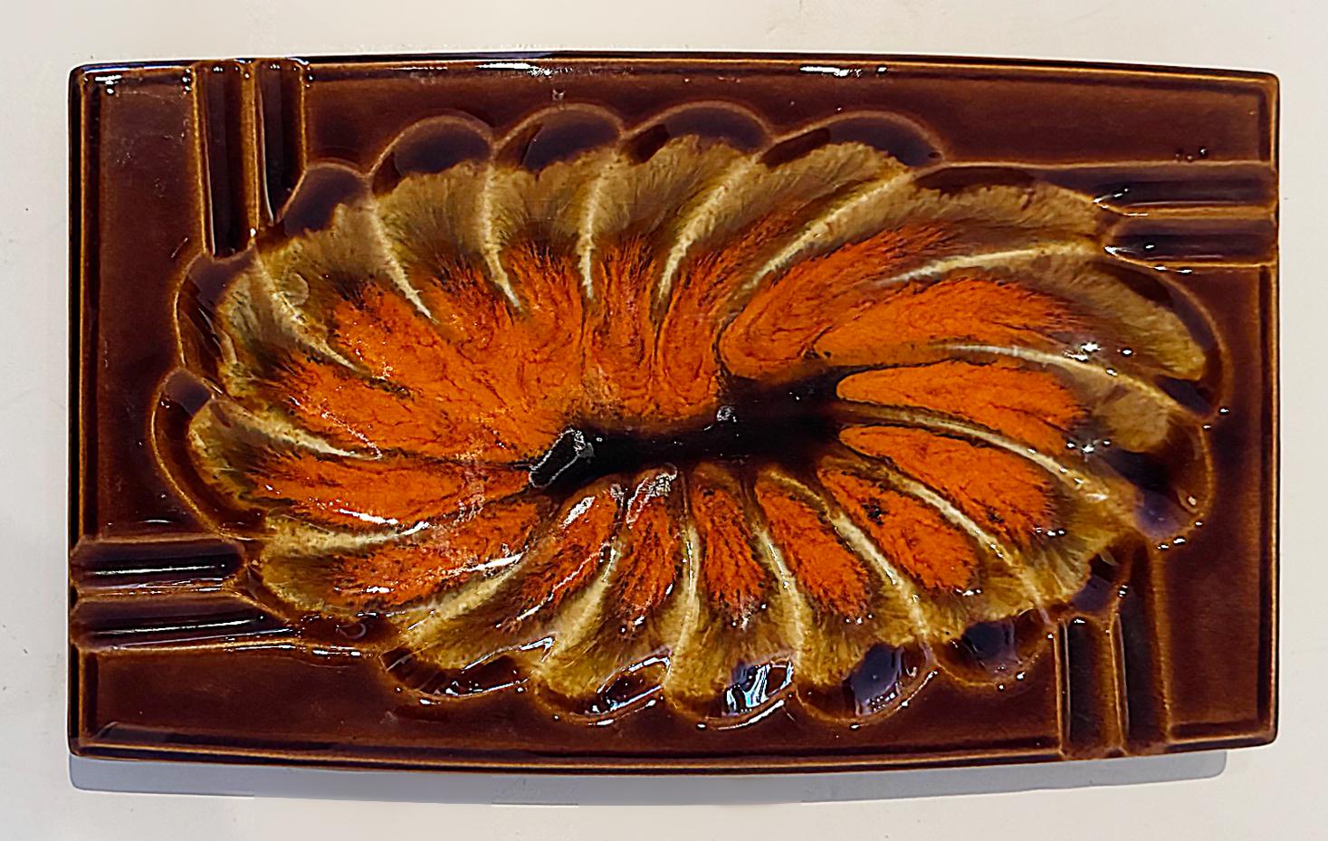 Mid-century Japanese Abstract Floral Ashtray In Orange, Brown, and Tan

Offered for sale is a Mid-century Modern ceramic glazed ashtray created in iconic Mid-century colors. The base is marked Japan.
