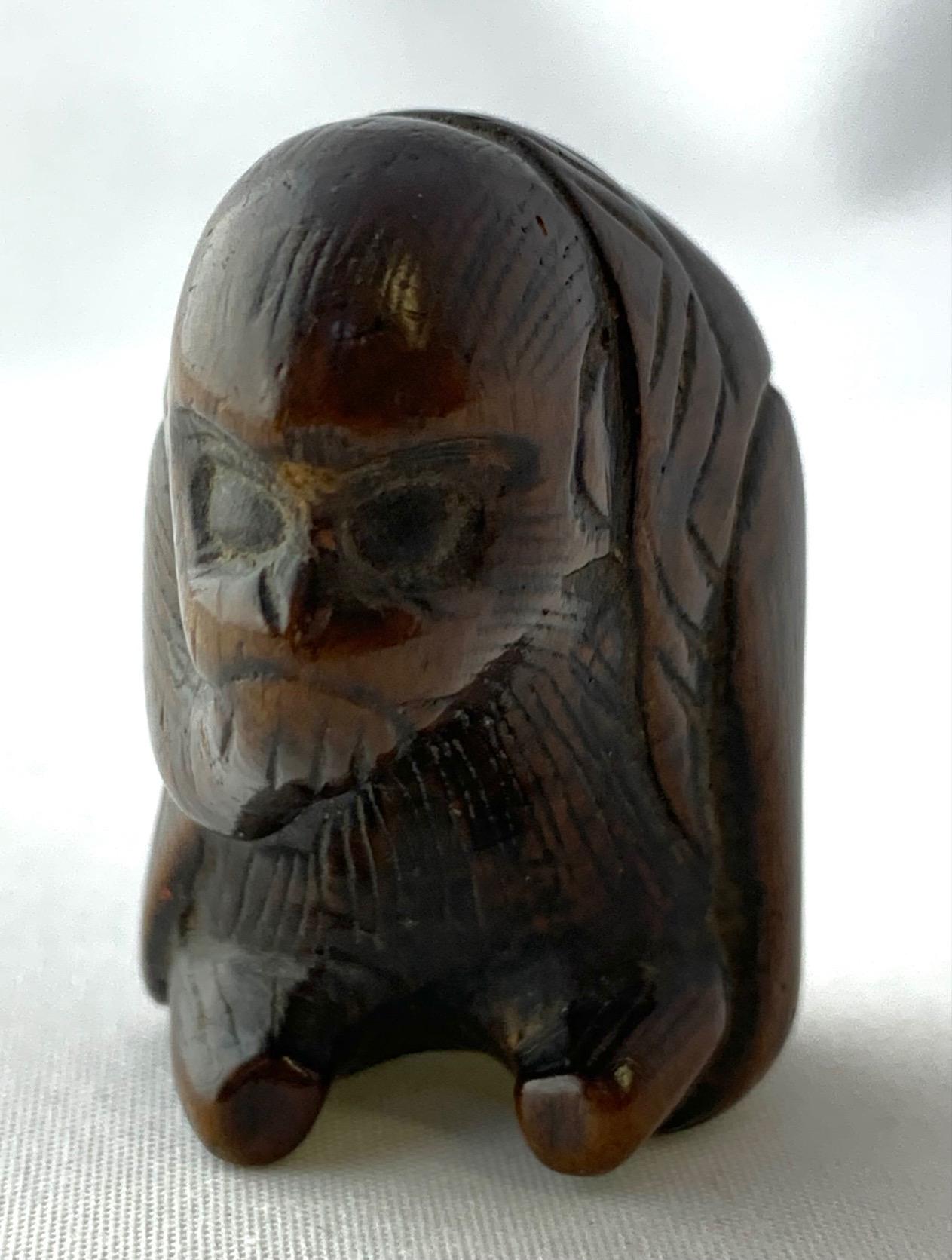 Netsuke di metà secolo intagliato a mano che raffigura una scimmia contemplativa in posizione seduta. Le scimmie rappresentano molteplici aspetti nella cultura e nel folklore giapponese, tra cui: i mediatori tra gli uomini e gli dei, la longevità e