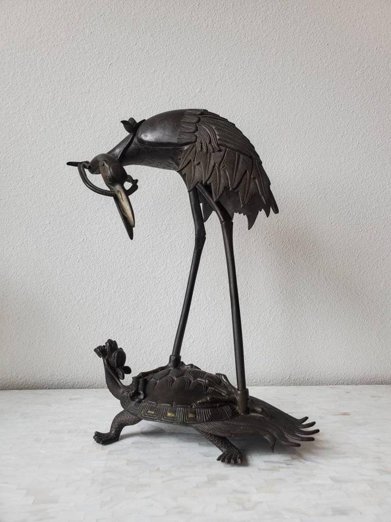 A classic Japanese sculpture of a tall legged heron and tortoise or turtle shelled dragon. Whimsical and charming, the vintage two piece work sculpted of high quality solid bronze, nicely patinated, richly detailed, depicting a Japanese heron with a