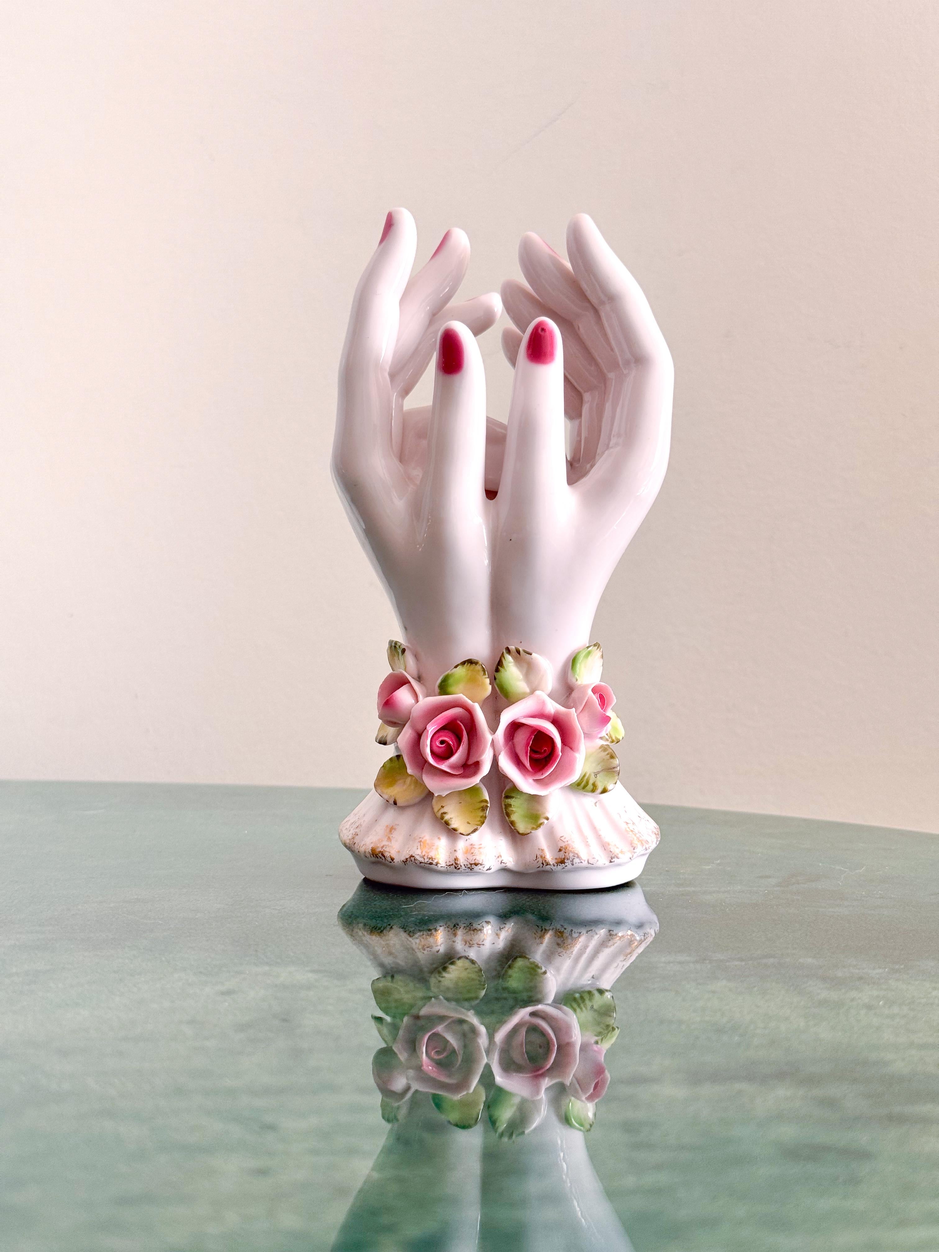 Precioso jarrón de porcelana japonesa de mediados de siglo de L'Amour China, con un exquisito par escultórico de manos ahuecadas adornadas con delicadas rosas rosas pintadas a mano y suaves hojas verdes. Fabricada en Japón y marcada 