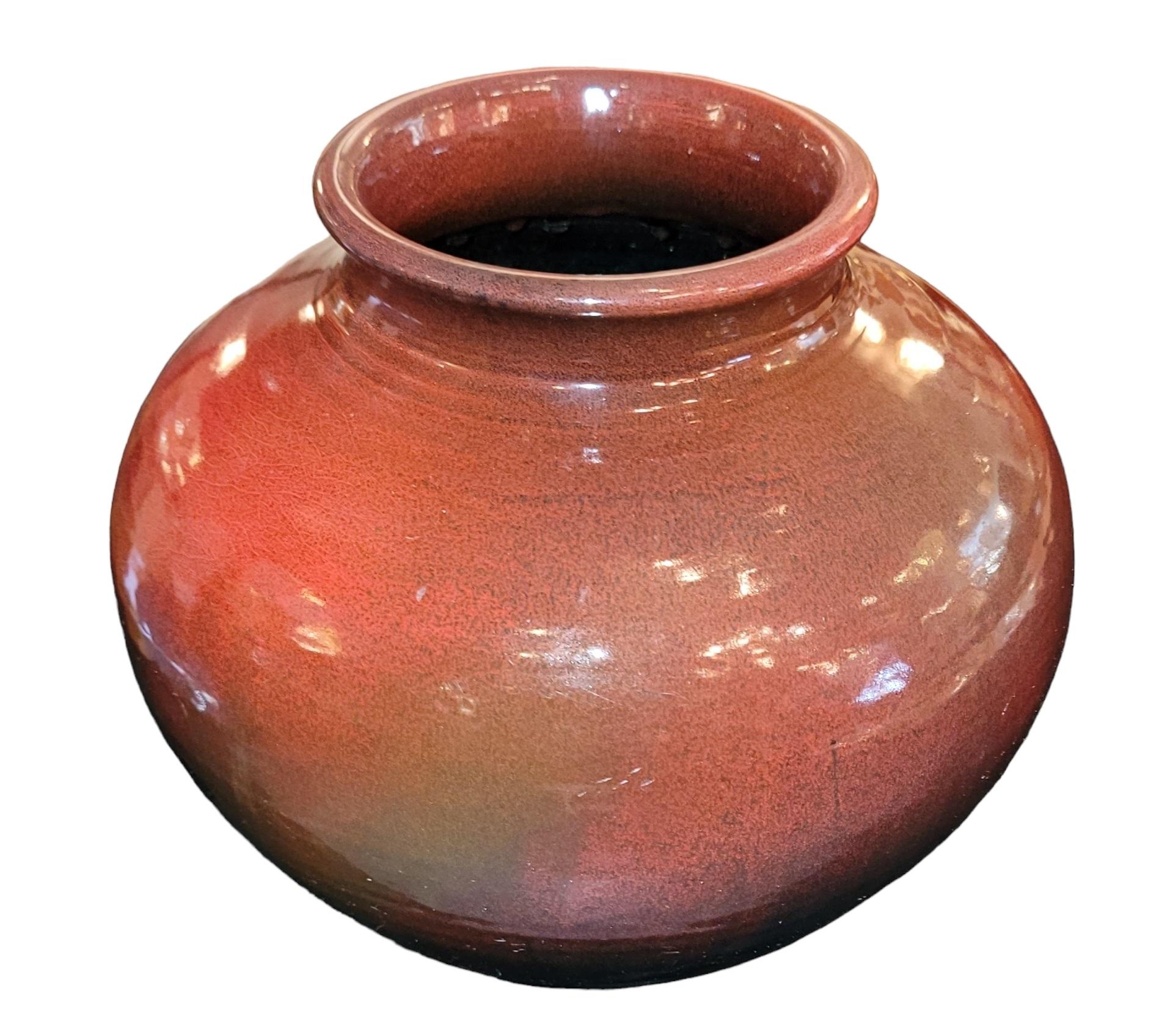 This magnificent pot is glazed in a red into black color.