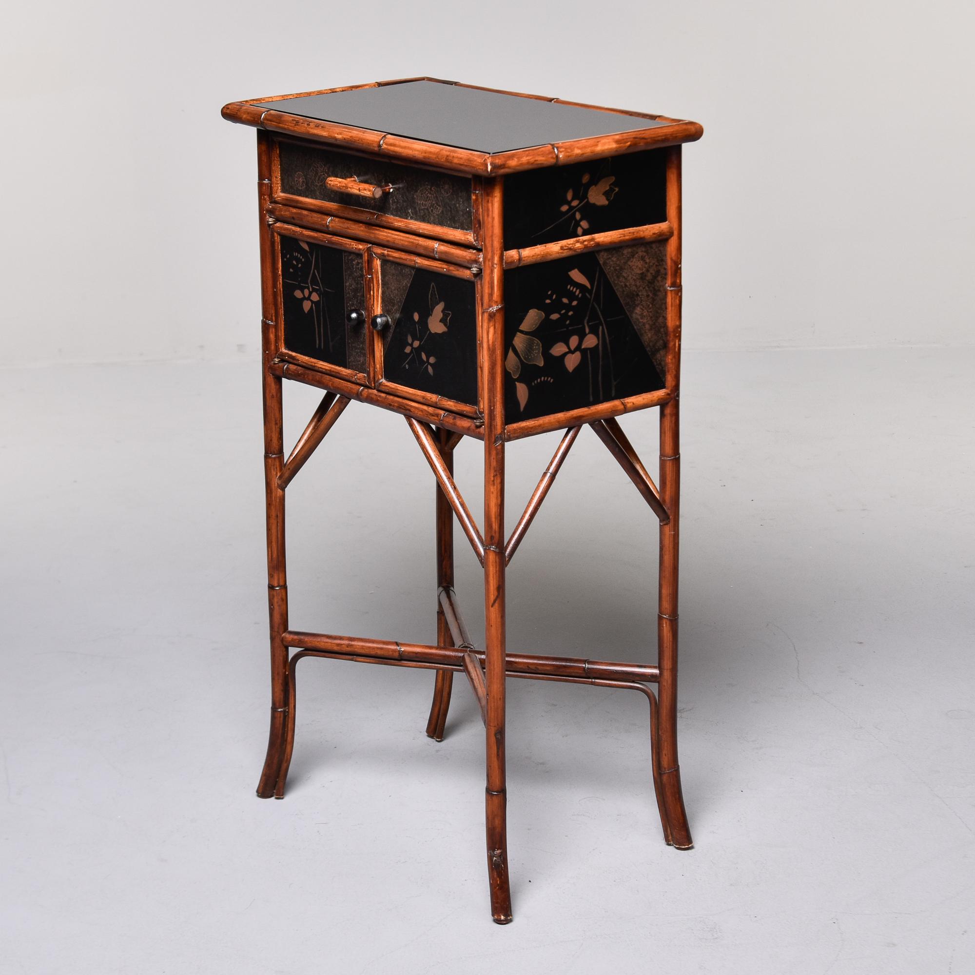 Found in the US, this Japanese style cabinet dates from the late 1960s, early 1970s. Small cabinet has a bamboo frame with a painted black lacquer small cabinet. Single functional top drawer with two hinged doors that open to storage below. We had a