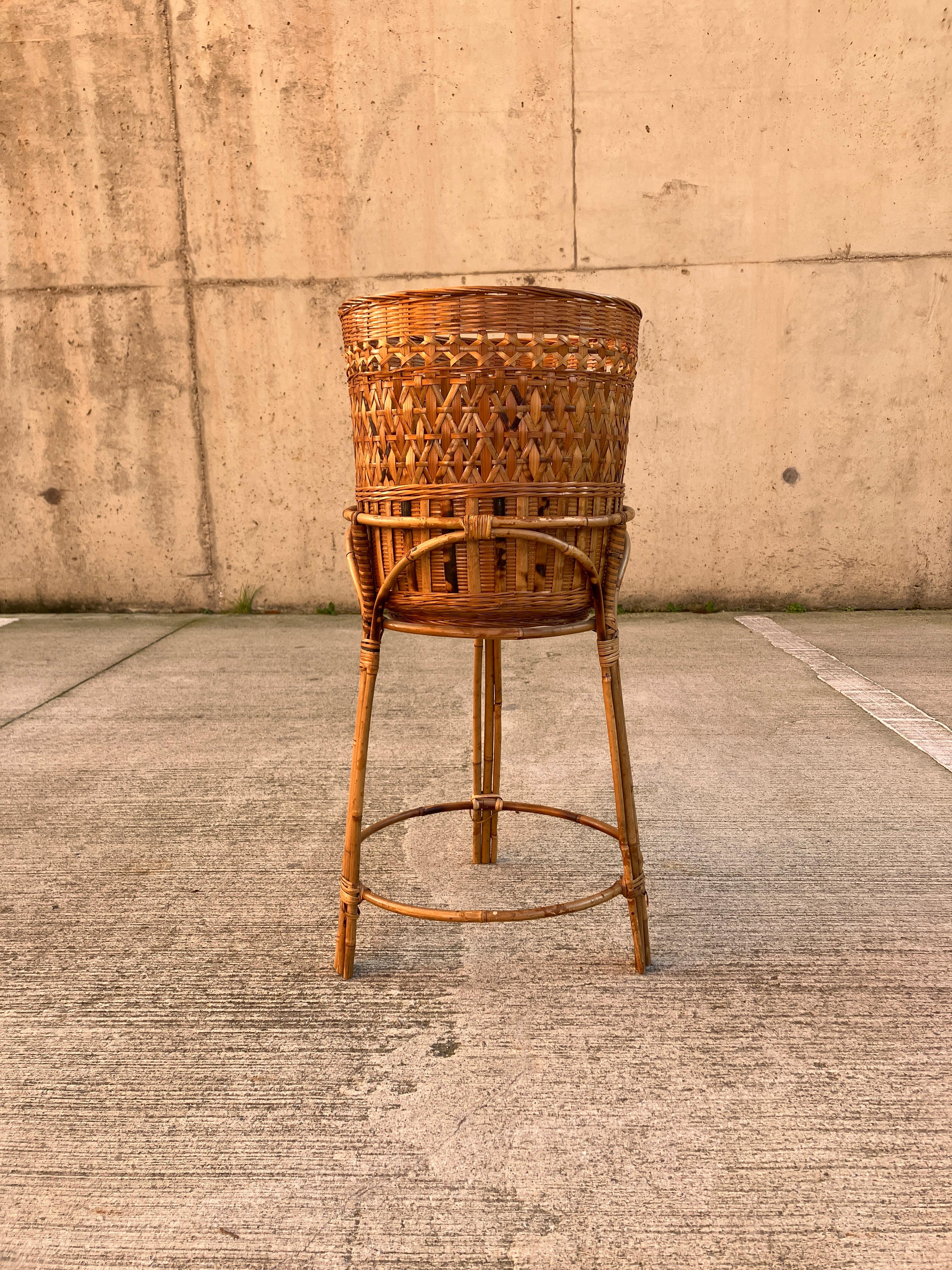 A gorgeous jardiniere in rattan. This mid-century plant stand is large enough for a very large house plant. The plant pot measures 32cm in diameter. Overall the stand and pot are 68cm high and the stand is 39cm in diameter at the base. 
There are