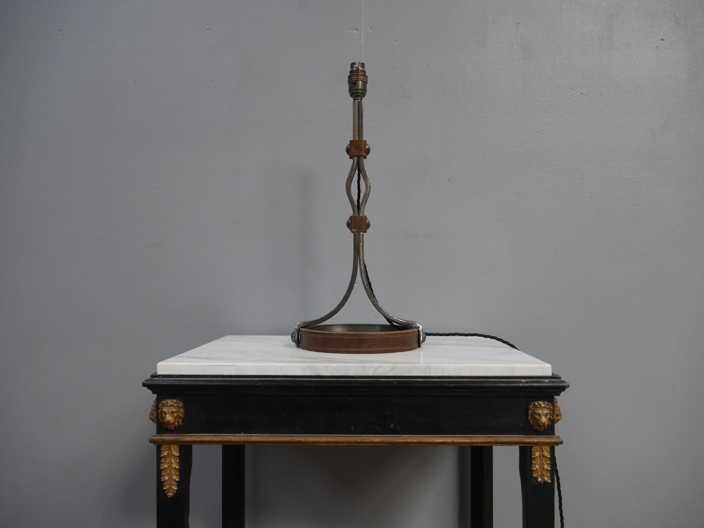 An iron & leather table lamp by Jean Pierre Ryckeart.
A beautiful piece of mid century design with the simple yet elegant lines in thick wrought iron with riveted leather banding to the upright and base.
An beautiful thing.
Wired in twisted black