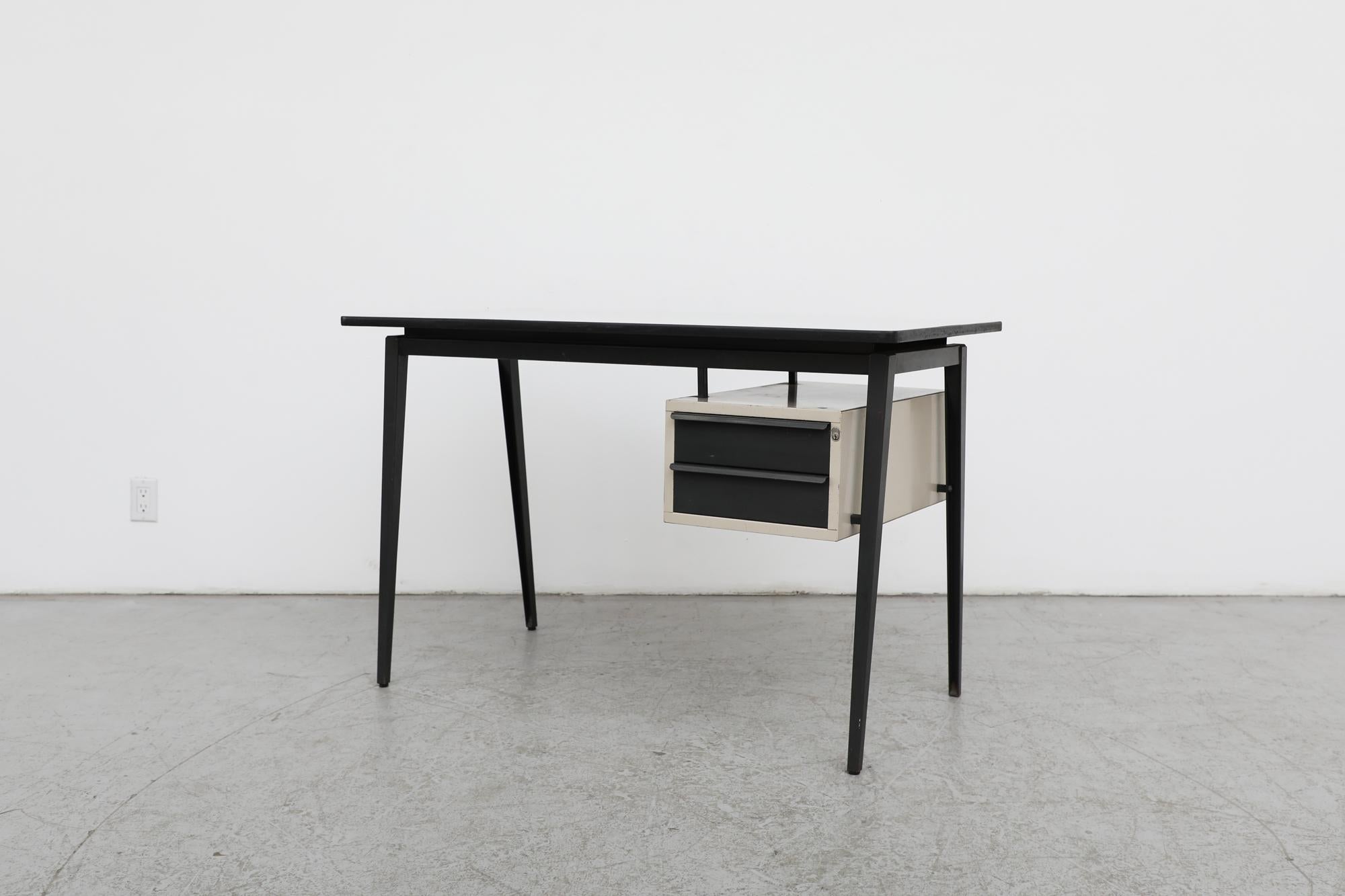 Mid-Century industrial desk for Marko. Formica top with black enameled metal Prouve inspired compass legs and small grey two drawer side cabinet. Perfect in a creative studio or stylish office. setting. The lock no longer functions and frame has
