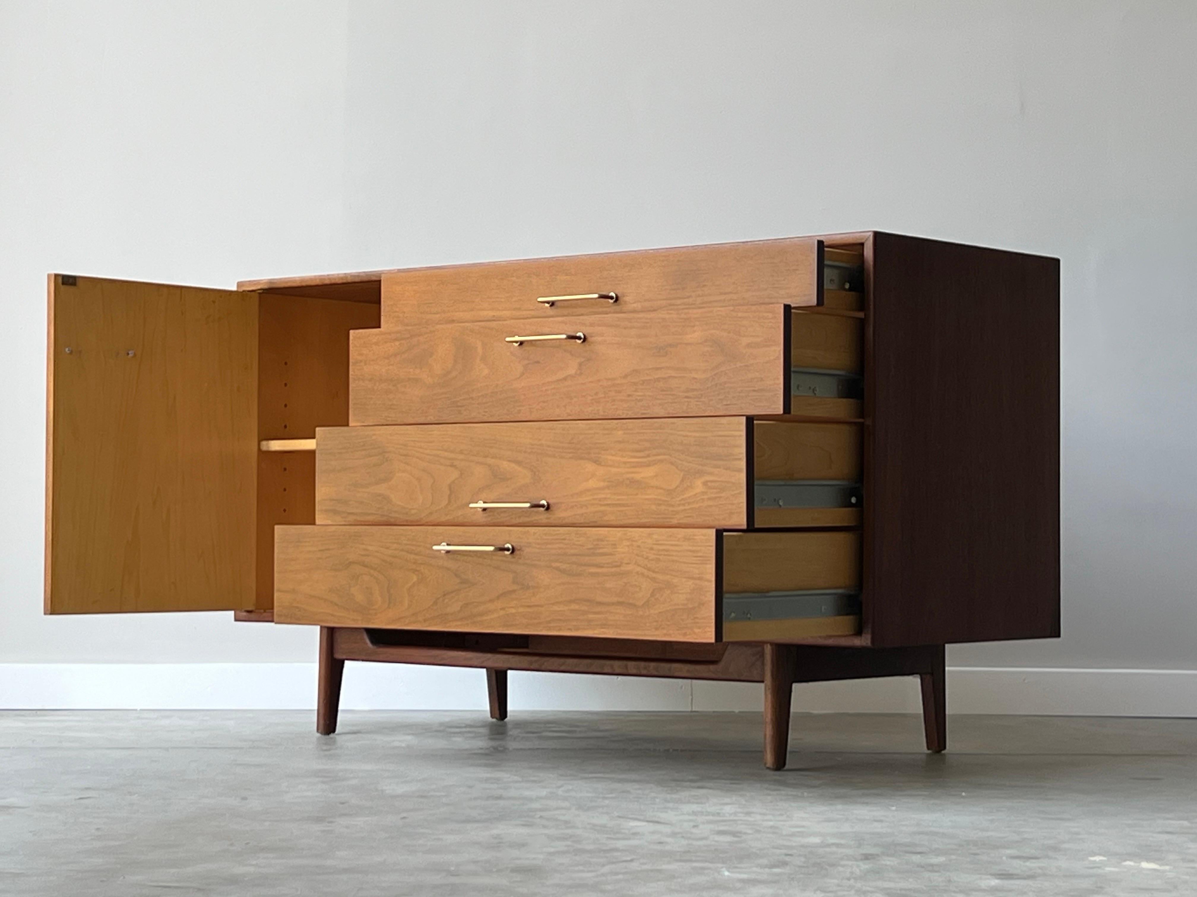 This perfect sized credenza that lacks very little. Beautiful design, dramatic stance, solid construction, and beautiful walnut grain. Four smooth drawers and nice sized cabinet with adjustable shelf all with brass handles. Designed by a iconic