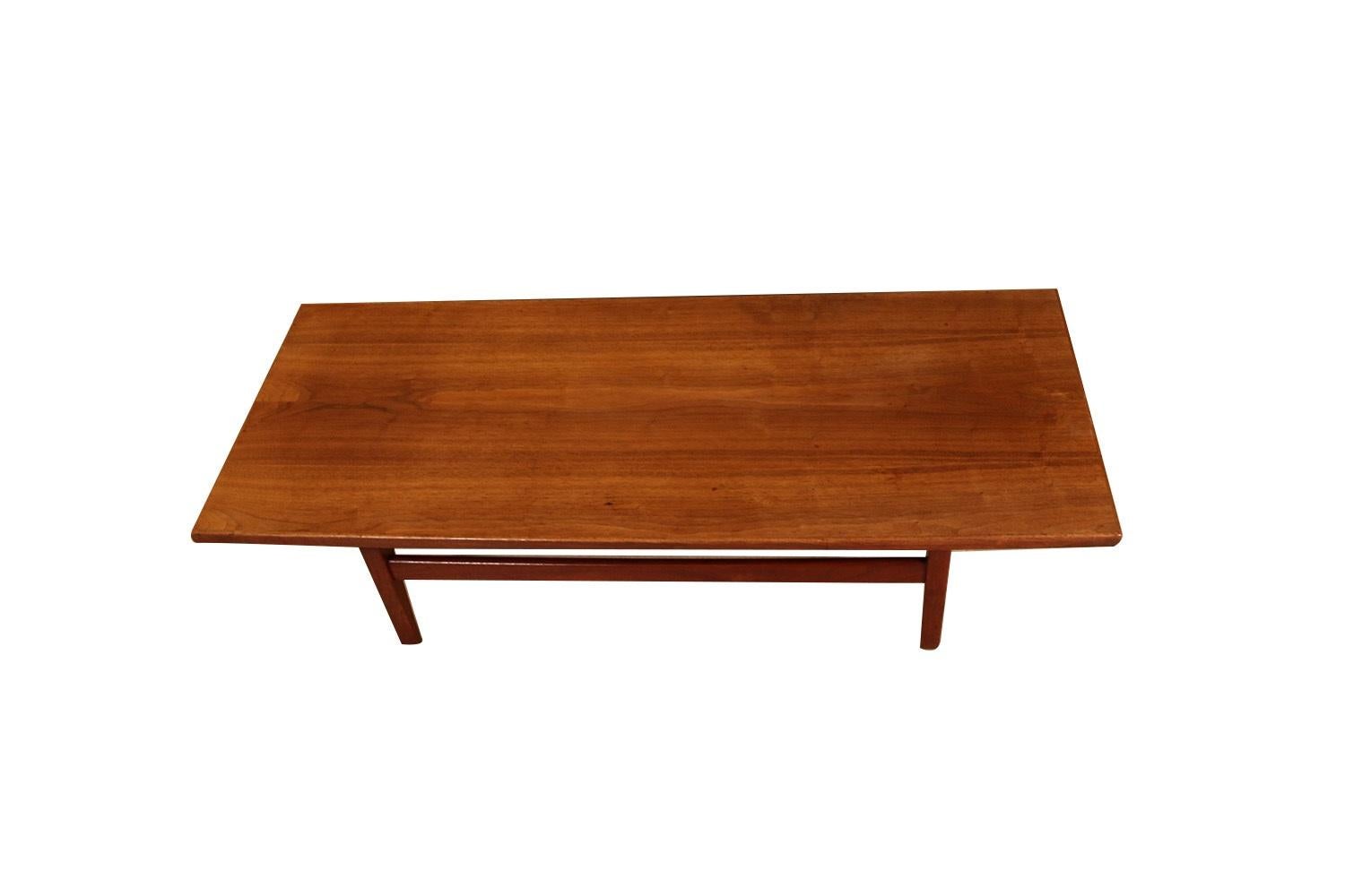 Vintage midcentury 1960s modern walnut coffee table, long bench by Jens Risom. This beautiful Jens Risom table features walnut top gracefully suspended above tapered and flared legs. The rich warm walnut patina has warmed and mellowed creating a