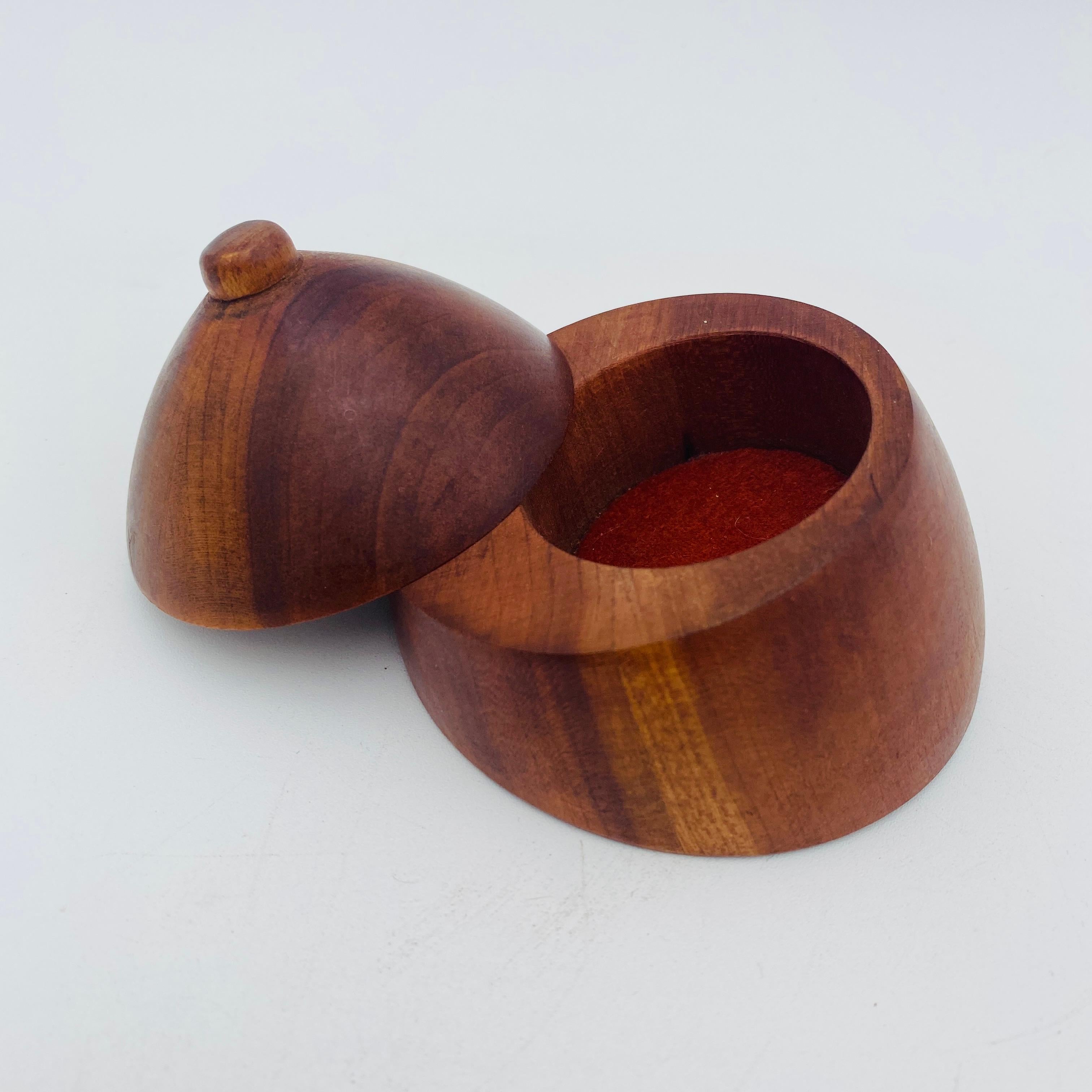 This is a beautiful hand carved wood jewelry box in the style of Dean Santner. The boob shaped box twists open easily to reveal a compartment with felt perfect for storing jewelry. 