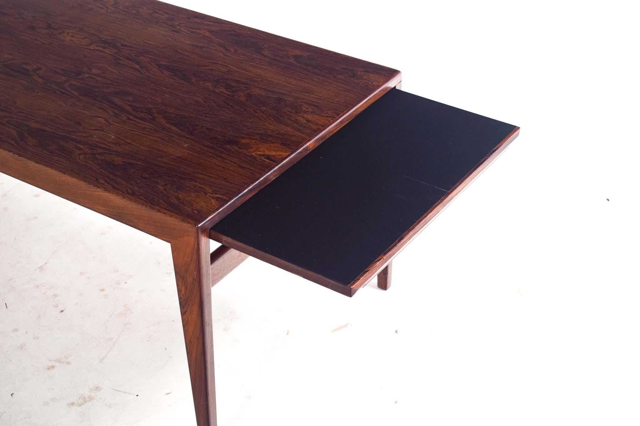 Cette table basse exquise du milieu du siècle, signée Johannes Eleg, est un exemple magistral du design scandinave, réputé pour son élégance discrète et sa fabrication impeccable. Fabriquée en palissandre luxueux, la table présente les grains riches