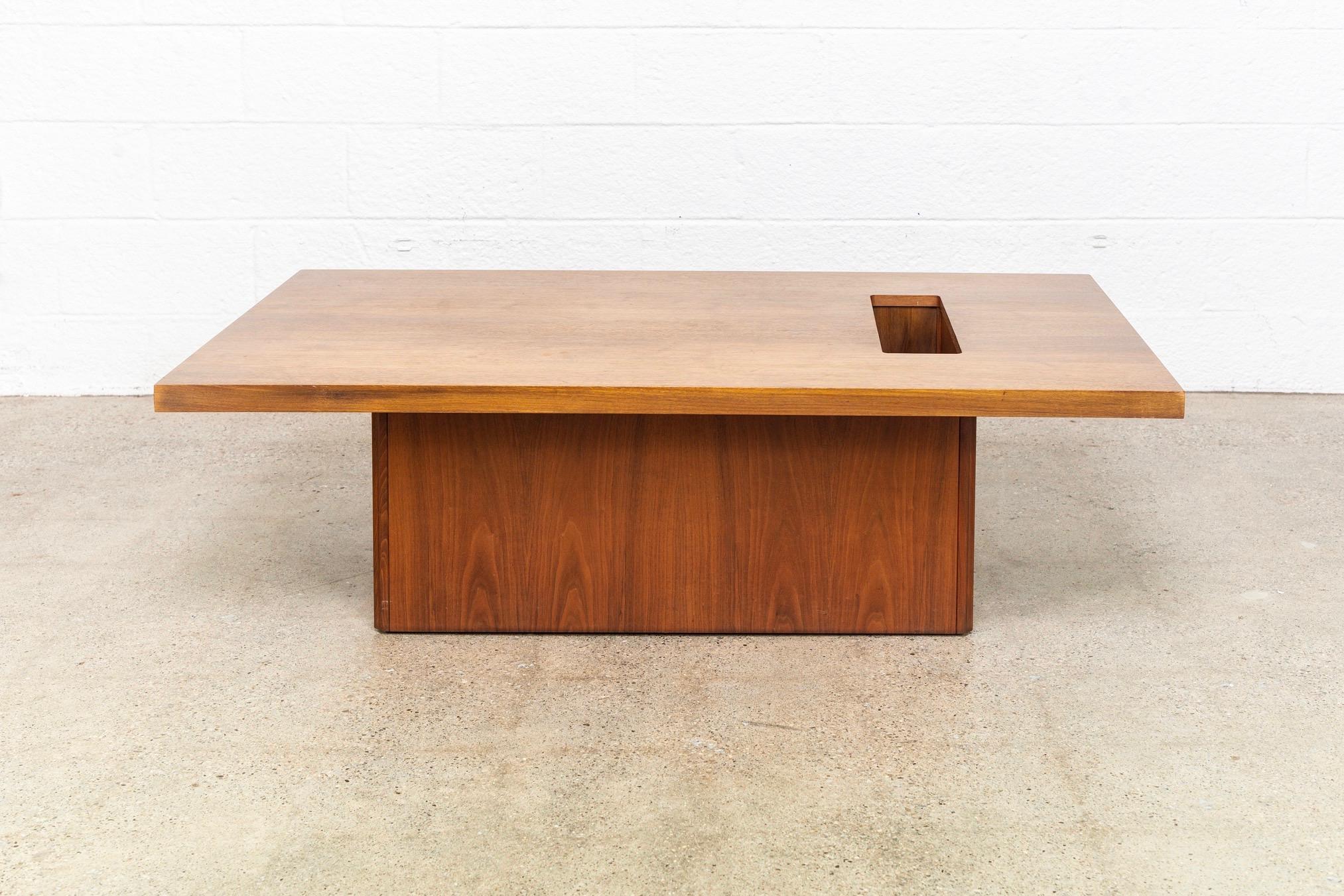 This vintage Mid-Century Modern Brown Saltman coffee table designed by John Keal circa 1960 has a Classic Minimalist design with a low profile and clean geometric lines. It is well constructed from solid walnut and walnut veneer with gorgeous wood