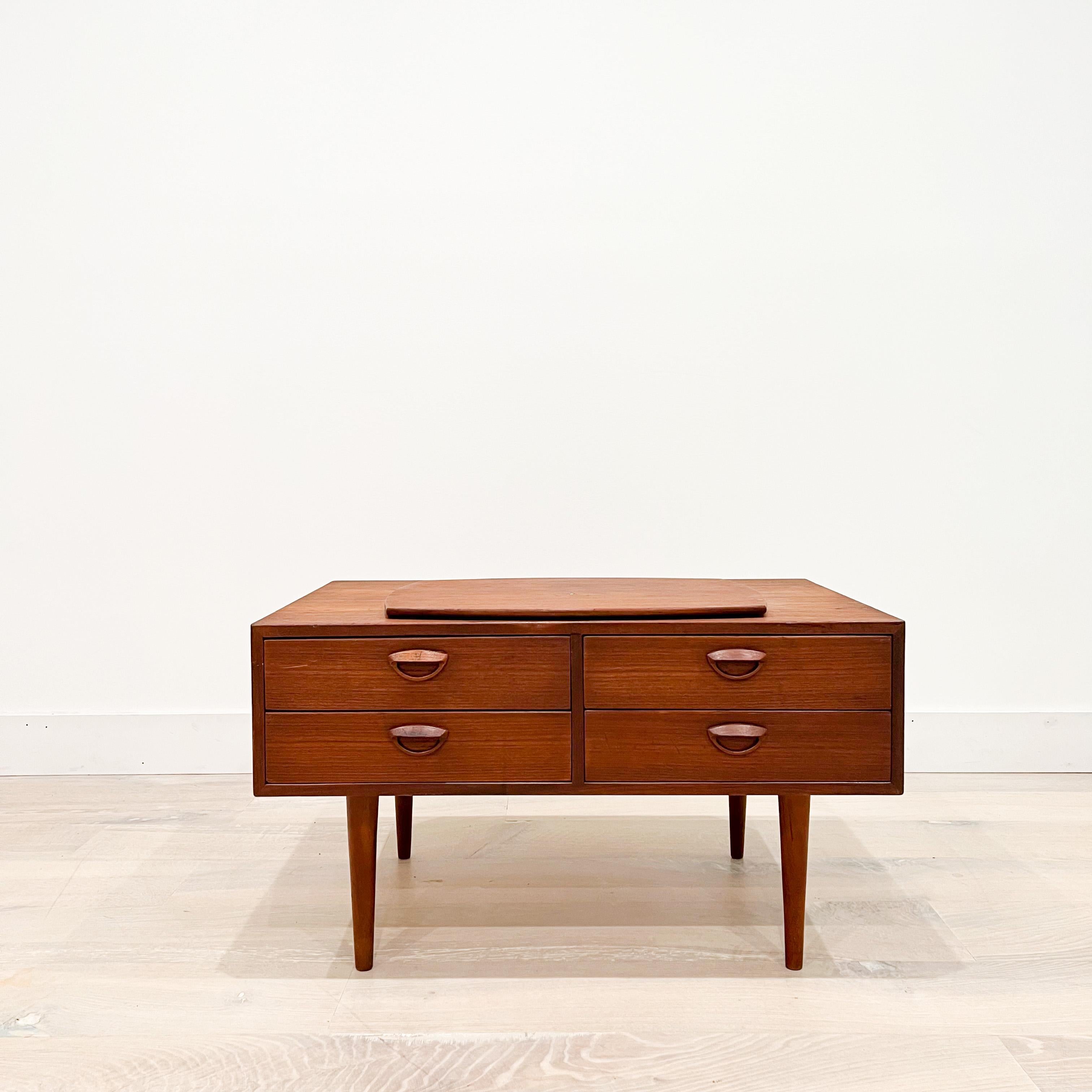 Small console or chest of drawers in teak designed by Kai Kristiansen, produced by Feldballes Møbelfabrik in the 1960s. The swivel top is perfect for a tv stand or other media devices. Features four drawers with carved handles. Very versatile design