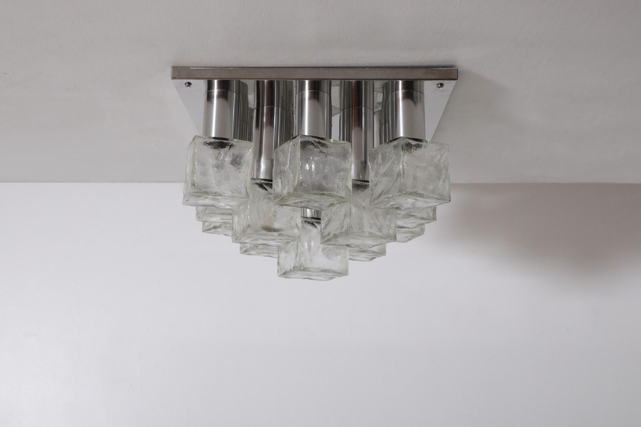 Chrome and glass flush mount ceiling light designed by J.T. Kalmar for Franken KG. Light has a flush base and 13 lights with tiered pressed glass cube shades. Kalmar, known for producing luxury luminaires and bespoke lighting, was founded in 1881.