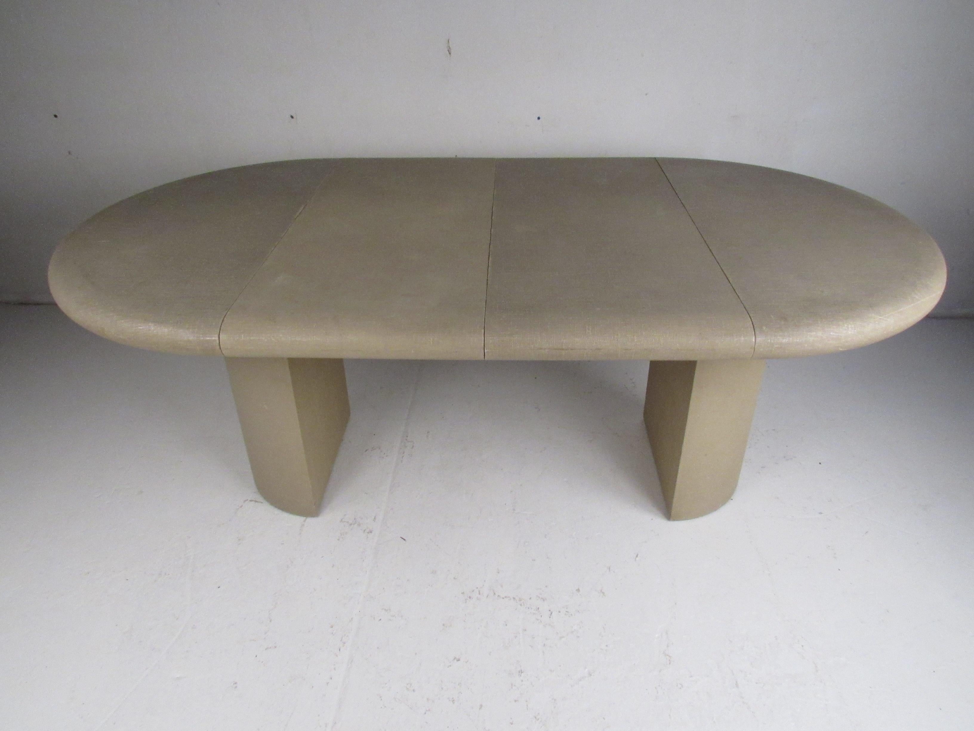This beautiful vintage modern dining table is covered entirely in grass cloth and boasts a pedestal base. A convenient design that includes two leaves allowing it to expand from 42 inches wide to 78 inches wide. A well made midcentury table with