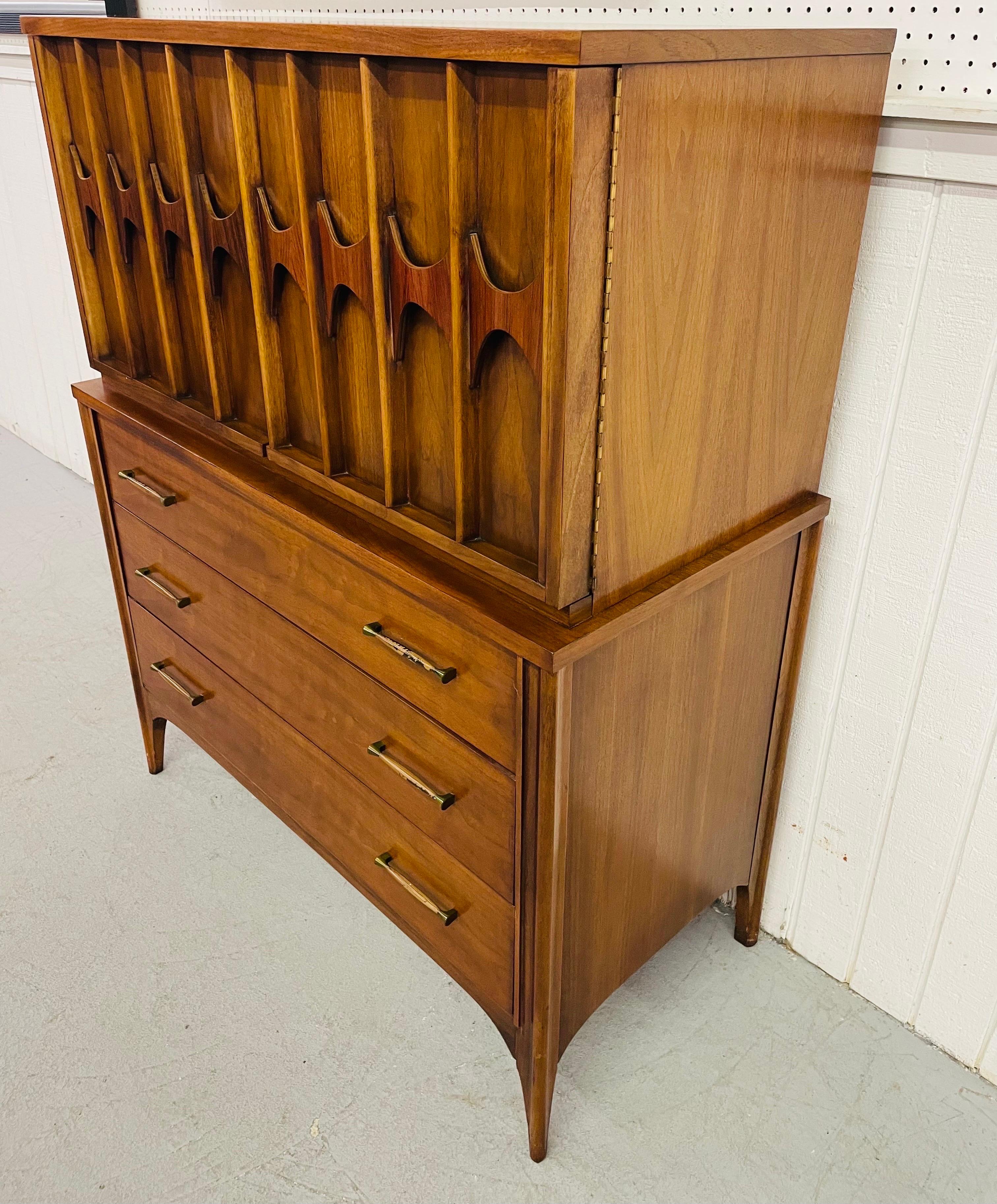 This listing is for a mid-century Kent Coffey Perspecta walnut gentlemen’s chest. Featuring two doors with carved rosewood pulls, two hidden drawers and one shelf behind the doors, three drawers at the bottom with original hardware, and a beautiful