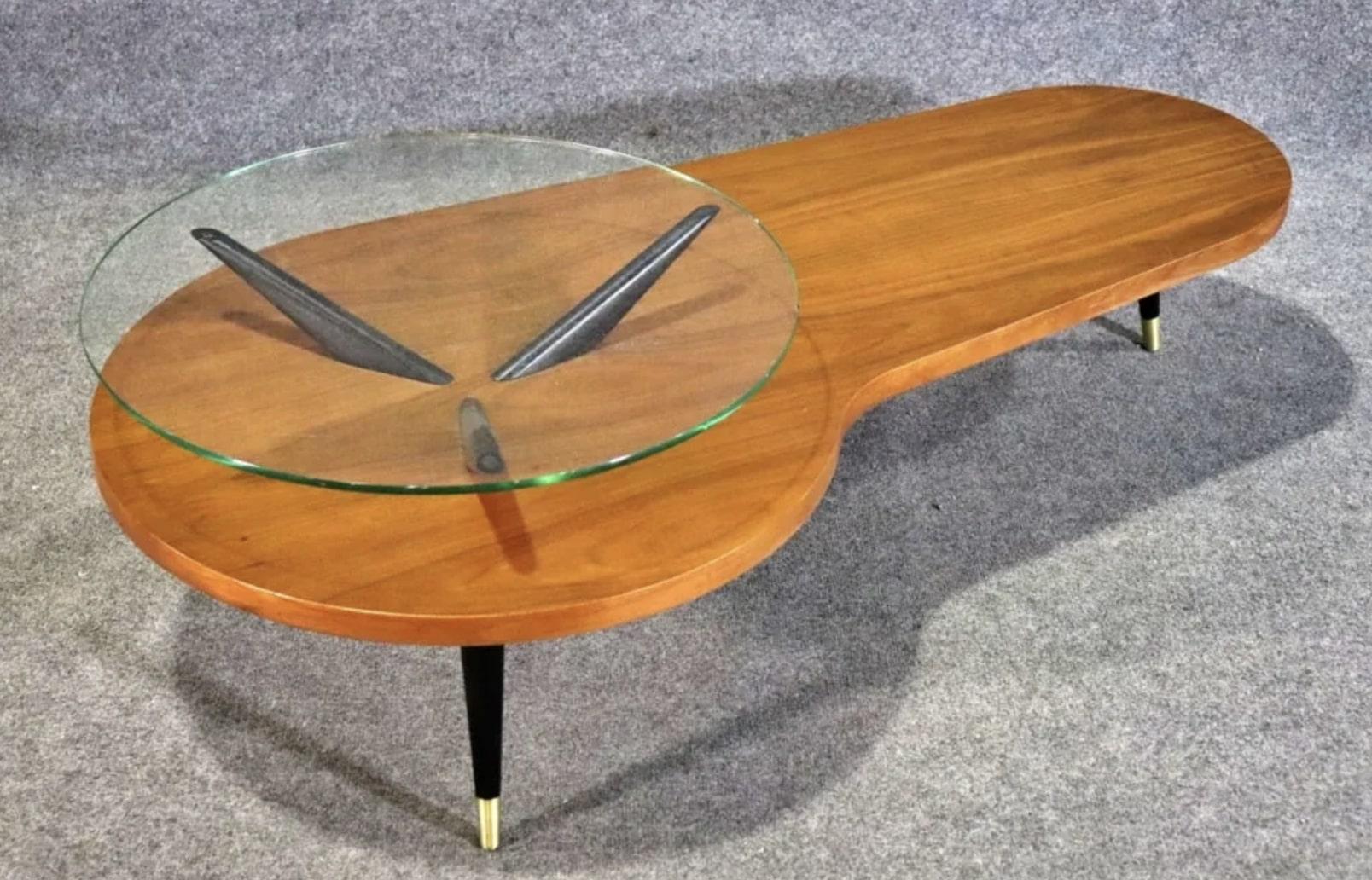 Table basse de style atomique en noyer et pieds noirs. La table en verre flottante repose sur une base en forme de rein.
Veuillez confirmer le lieu NY ou NJ