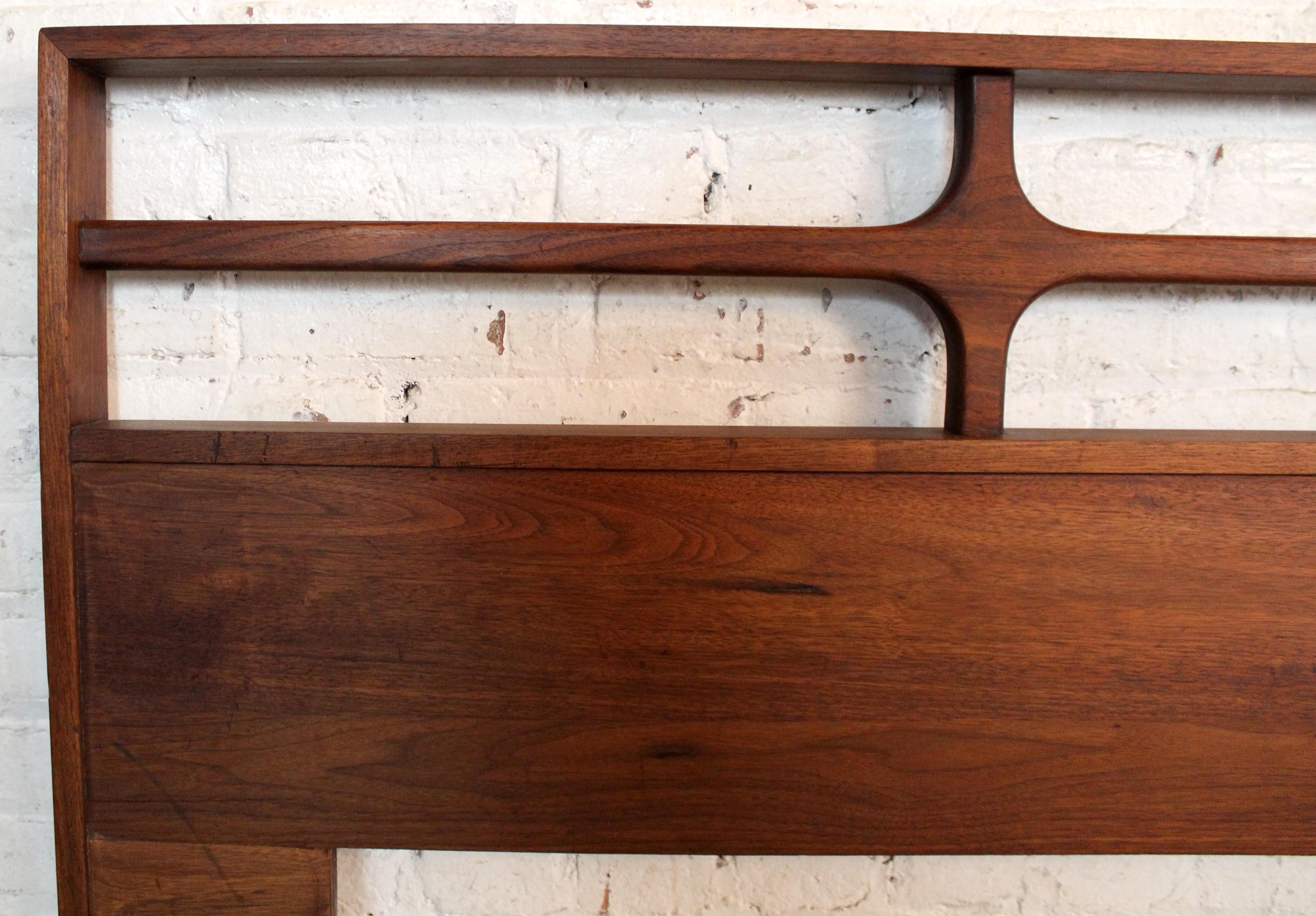 Apportez le charme et l'élégance du vintage dans votre chambre à coucher avec cette tête de lit attrayante de style moderne du milieu du siècle, construite en riche noyer américain. Avec un motif sculpté exquis évoquant les designs intemporels de