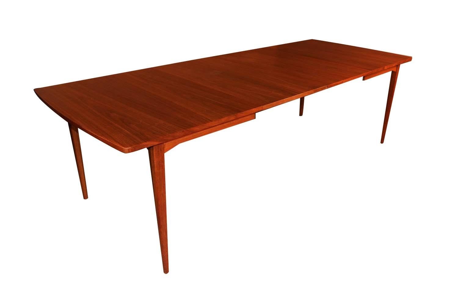 Beautiful Mid-Century Modern expandable dining table designed by Kipp Stewart for Drexel Declaration dated 1961. Features richly bookmatched grained, walnut, clean lines characteristic of Classic Danish design. Raised over four solid walnut tapered