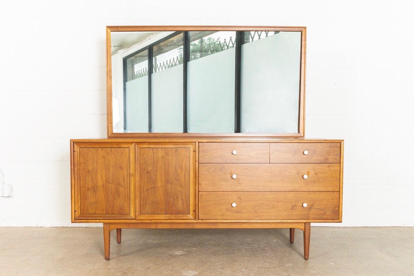 • Iconic Drexel declaration lowboy dresser with mirror designed by Kipp Stewart and Stewart McDougall, circa 1950.
• Sleek, elegant Mid-Century Modern styling.
• Impeccably crafted from walnut with beautiful natural grain.
• Original signature