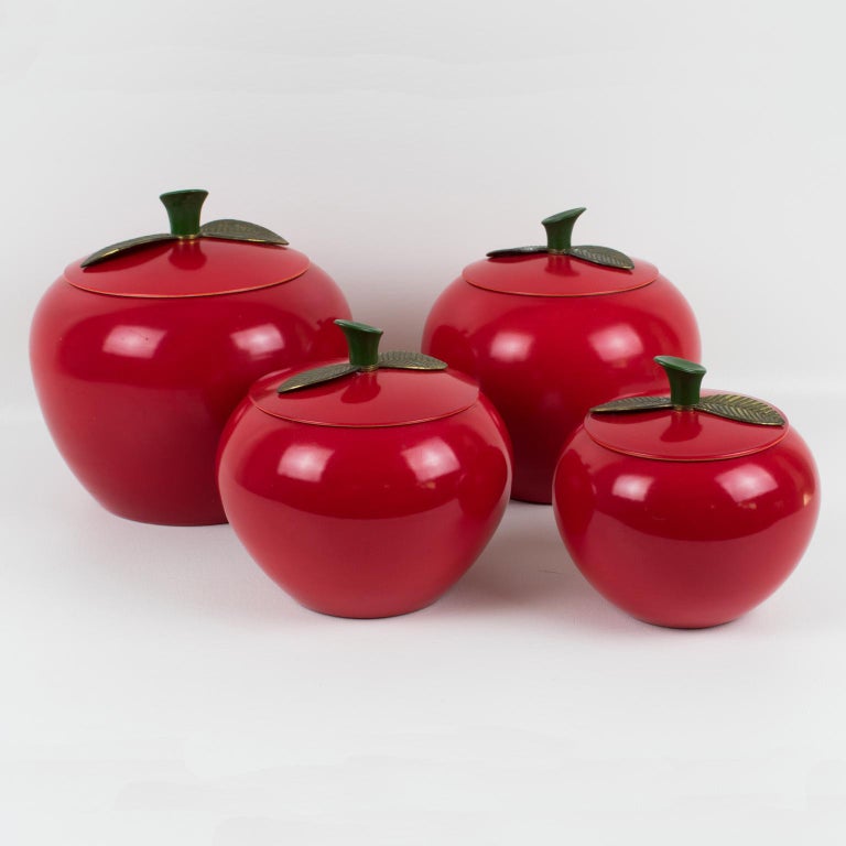 So cute Mid-Century-Modern 1960s kitchen canister or cookie jar, featuring apple-shaped container in red enamel aluminum in assorted graduated size. A lovely set of 4 pieces. The stem is in green hard plastic and the leaves are in green enameled