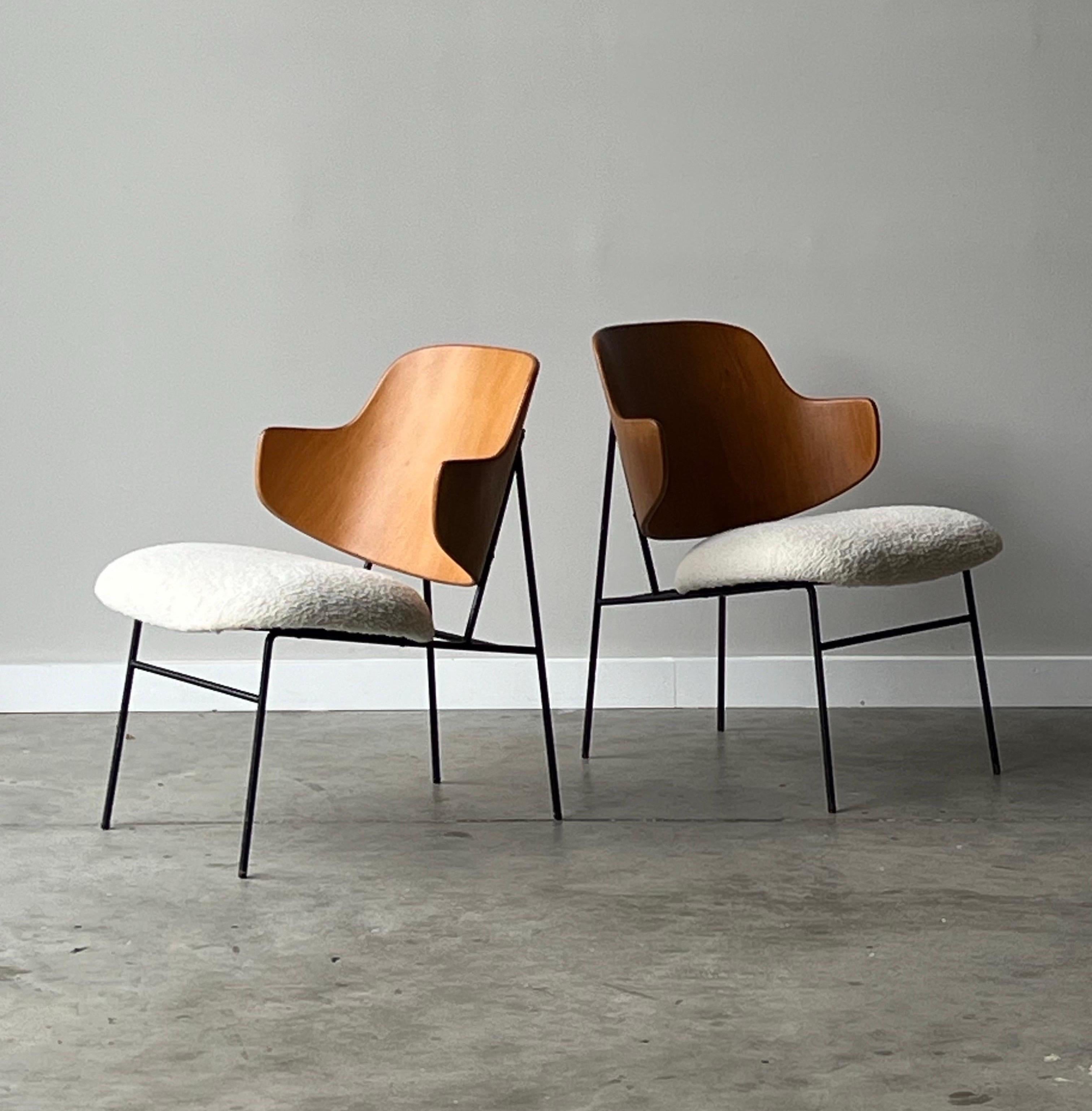 Mid-century pair of ‘Penguin’ accent chairs. Designed by Ib Kofod Larsen for Selig, Denmark. These iconic chairs were designed in the 1950s with a limited production in the 1960s. They feature a uniquely bentwood back with a geometric frame and