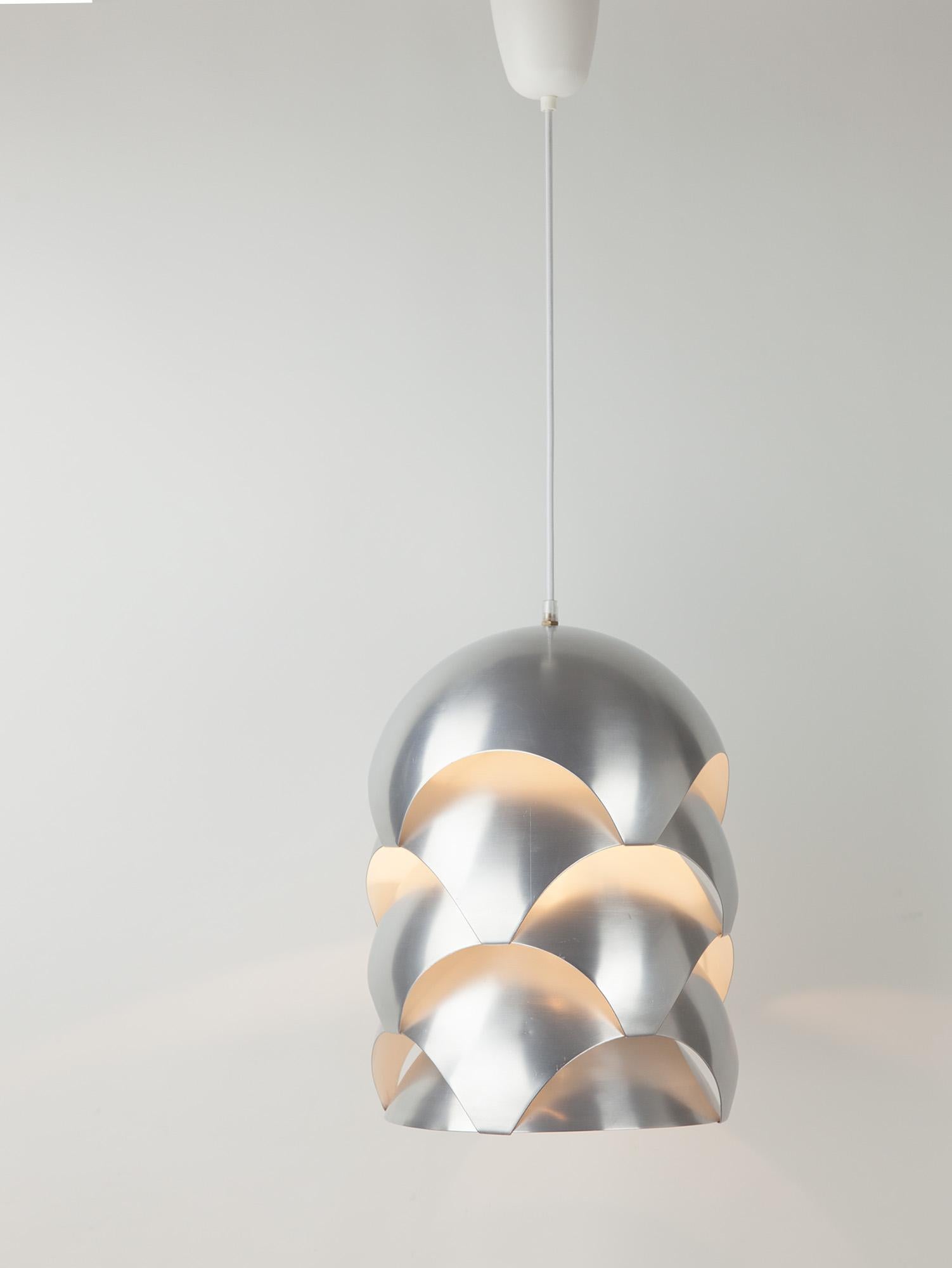 Very rare brushed aluminium ‘Kongelpendel’ pendant by Sven Ivar Dysthe for Sønnico. Four layered domed segments interlock and emit a soft light from the arched cutaways. The light bounces off the white internal walls in lovely soft tonal hues. The
