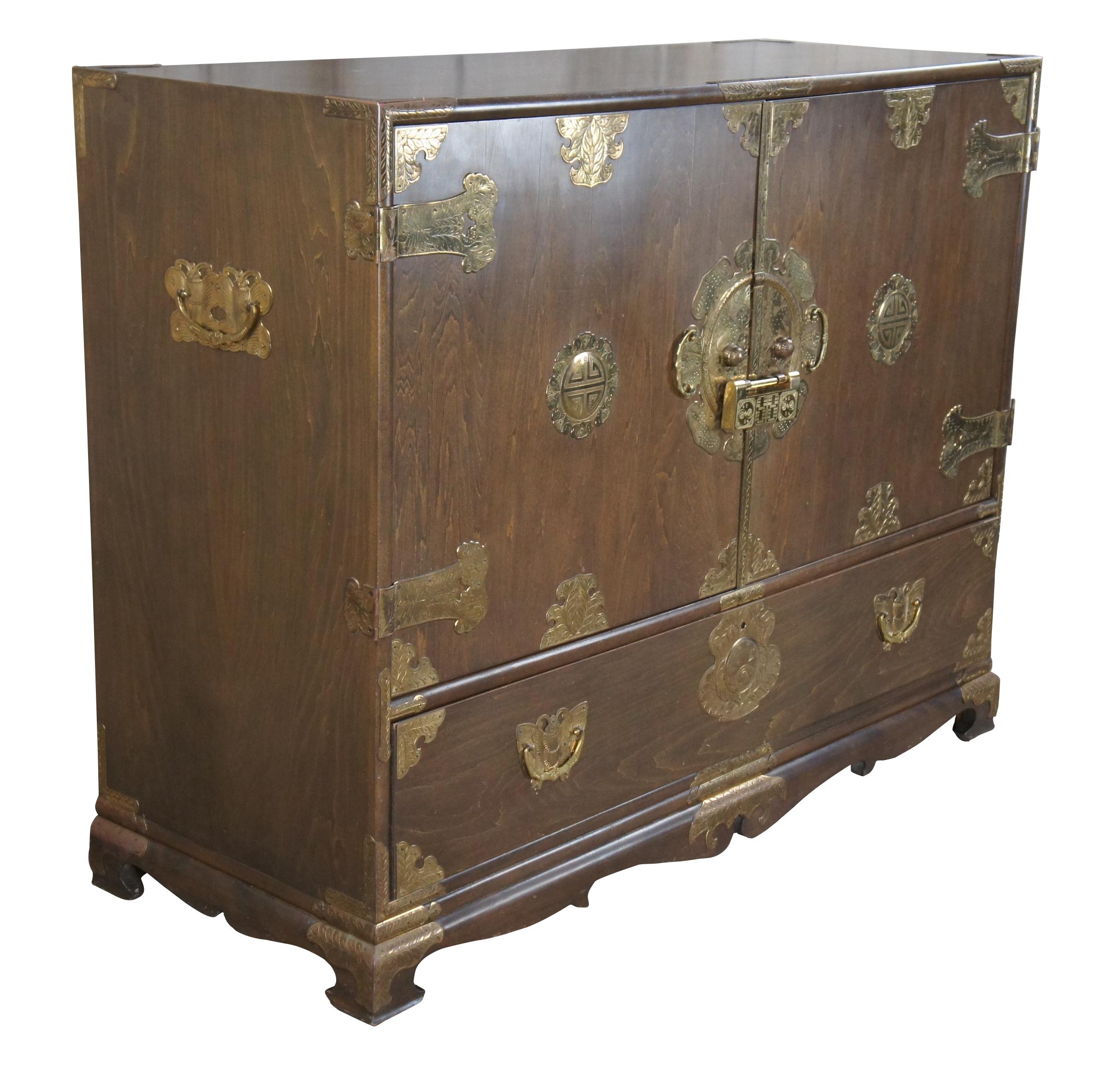 Mid-century Korean pine brass mounted silverware chest, sideboard / tansu. Featuring profuse engraved brass butterfly and medallion mounts, two blind doors revealing eight fitted interior upper drawers, and one lower long drawer. Includes ornate