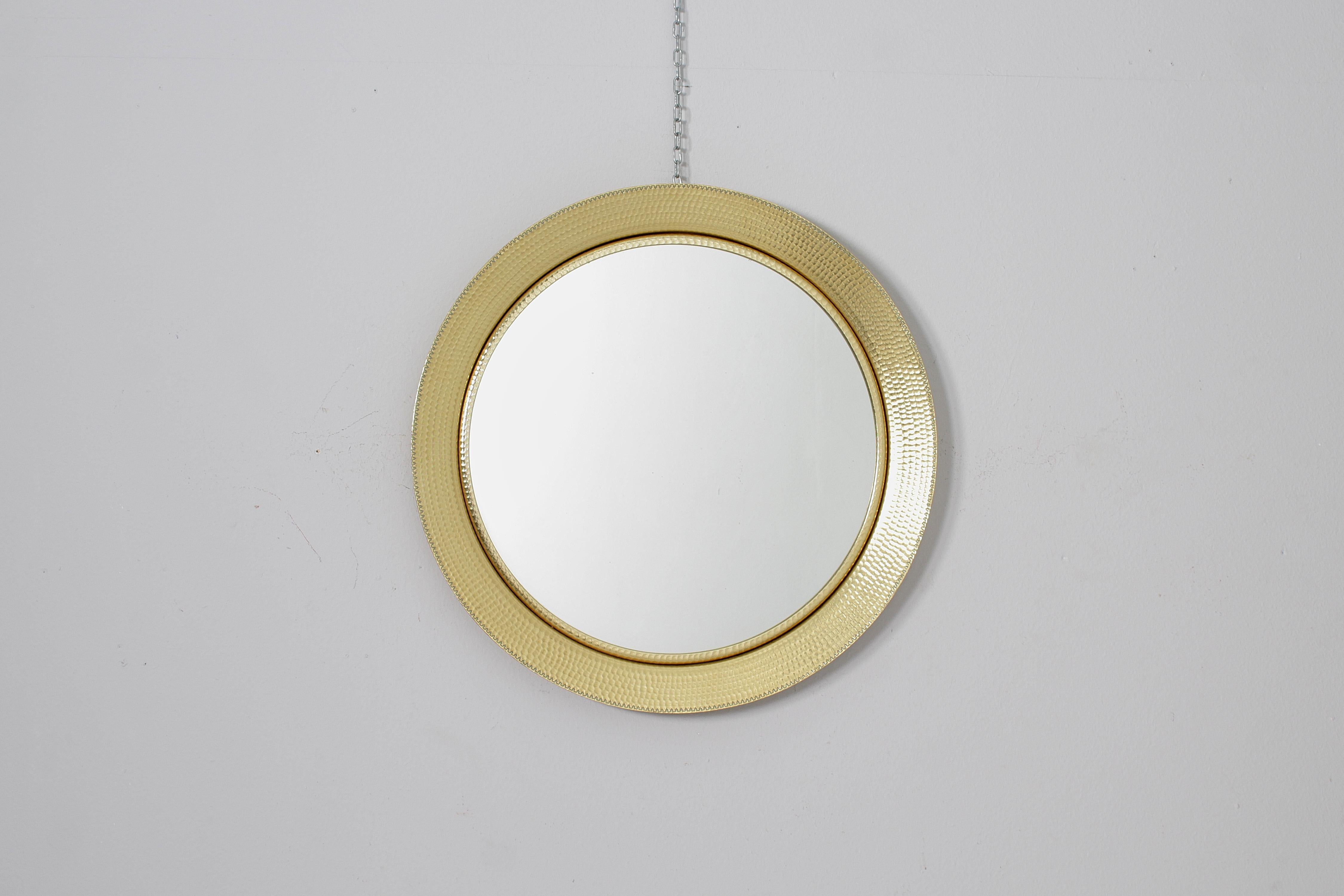 Beautiful round wall mirror with large frame enclosed in gilded aluminium, hammered with decorative engraving motif along the external circumference. Attributable to Lorenzo Burchiellaro, 60s Italy .
Wear consistent with age and use.