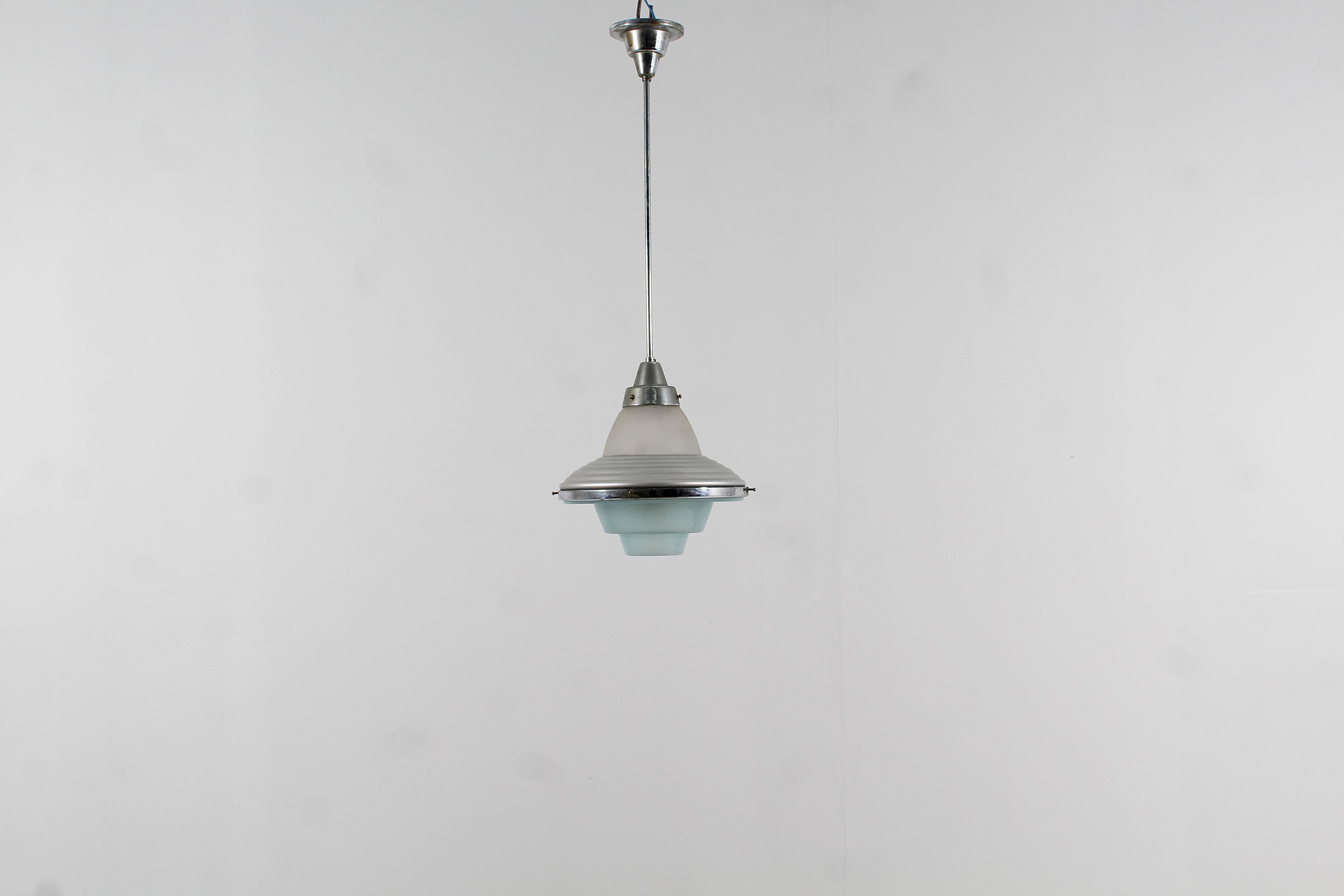 Suspension lamp in chromed metal and satin glass, white above, blue below, with diffuser geometric shaped attributable to Louis Kalff for Philips, Netherlands, 1950s. There are defects in the chrome visible in photos.
Wear consistent with age and