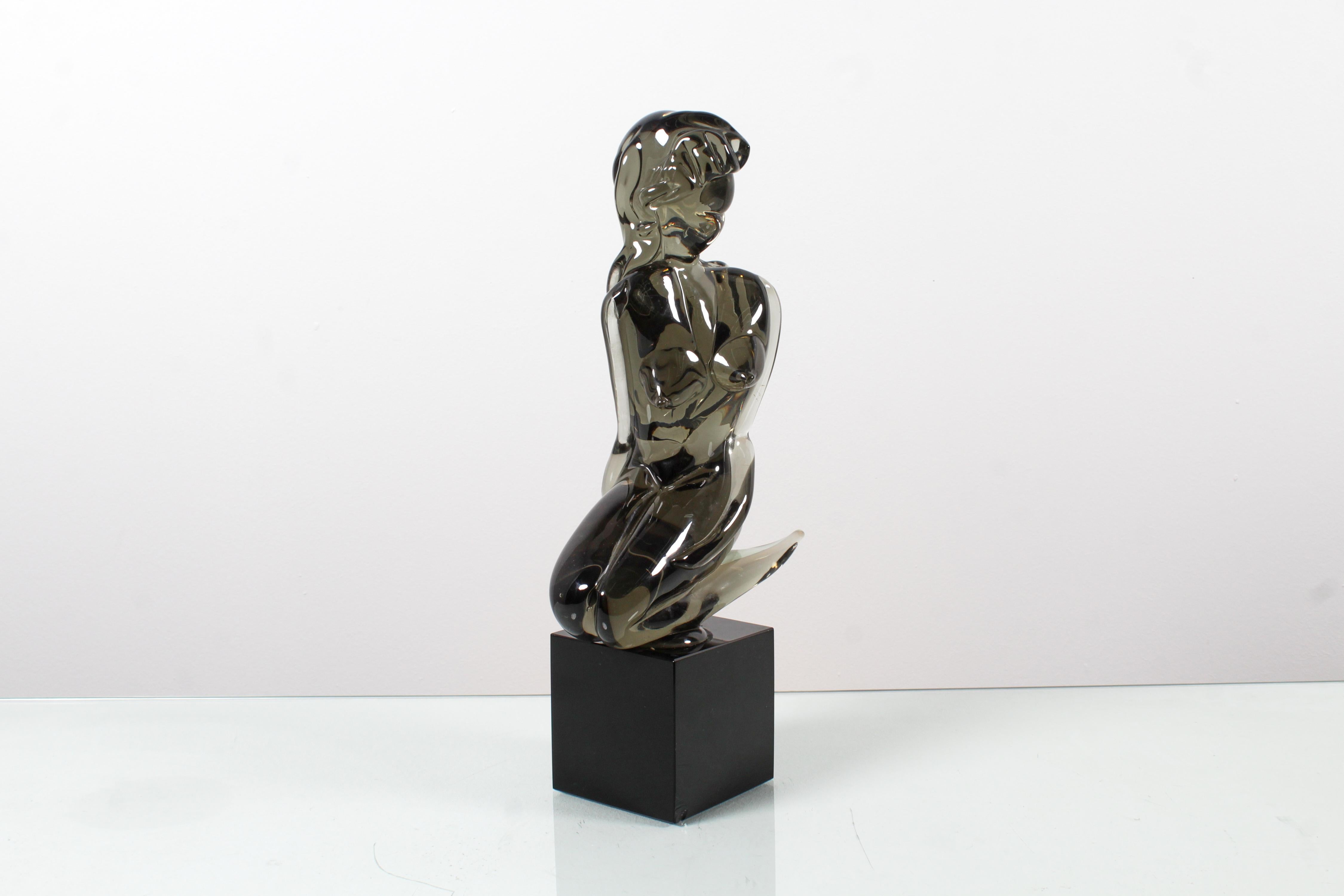Delightful sculpture depicting a stylized woman's body in smoky green Murano glass on a cubic black glass pedestal. The artwork, created in the 1970s, can be attributed to the Murano master Loredano Rosin (1936-1991).