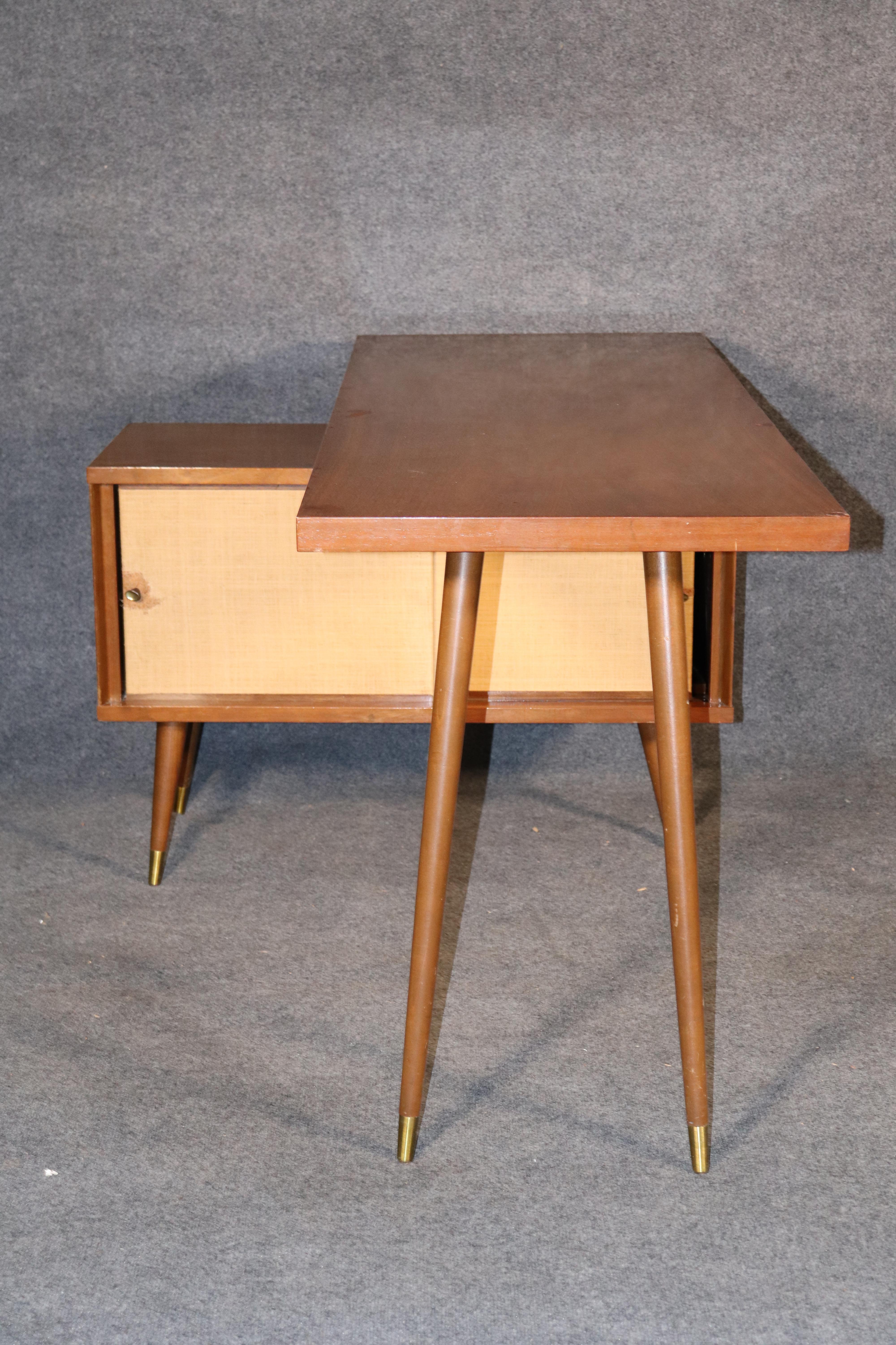 Unusual office desk with storage cabinet space. Paul McCobb style maple wood, cone legs and grass cloth cabinet.
Please confirm location.