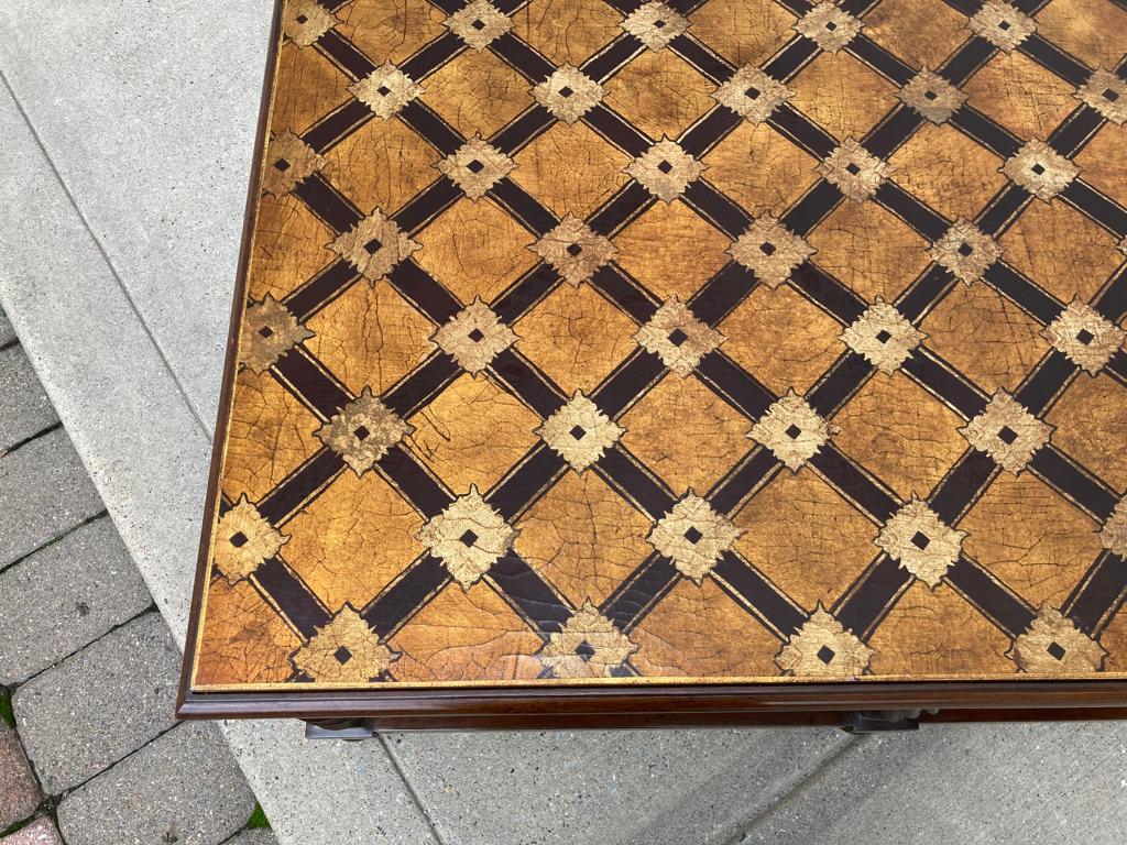 This large scale Mid-Century Modern coffee table has a stunning top with lacquered gilt and chocolate brown trellis decoration. The base is walnut with spiral legs over ball feet. The removable top is inset into the base showing the gilt sides. It