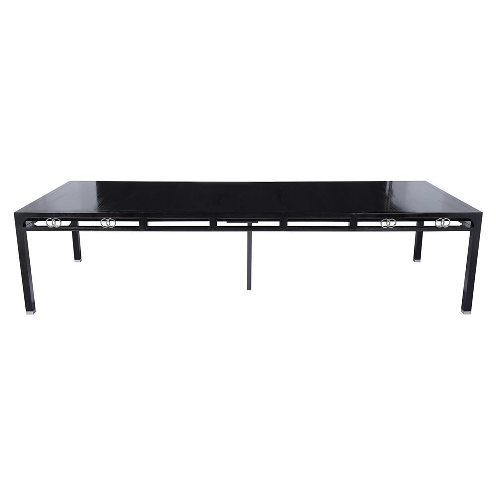 An elegant Mid-Century Modern 1970s extendable dining table handcrafted out of solid oak wood with a new ebonized lacquered finish and that has been fully restored. This unique table features an extendable top with three leaves that can be