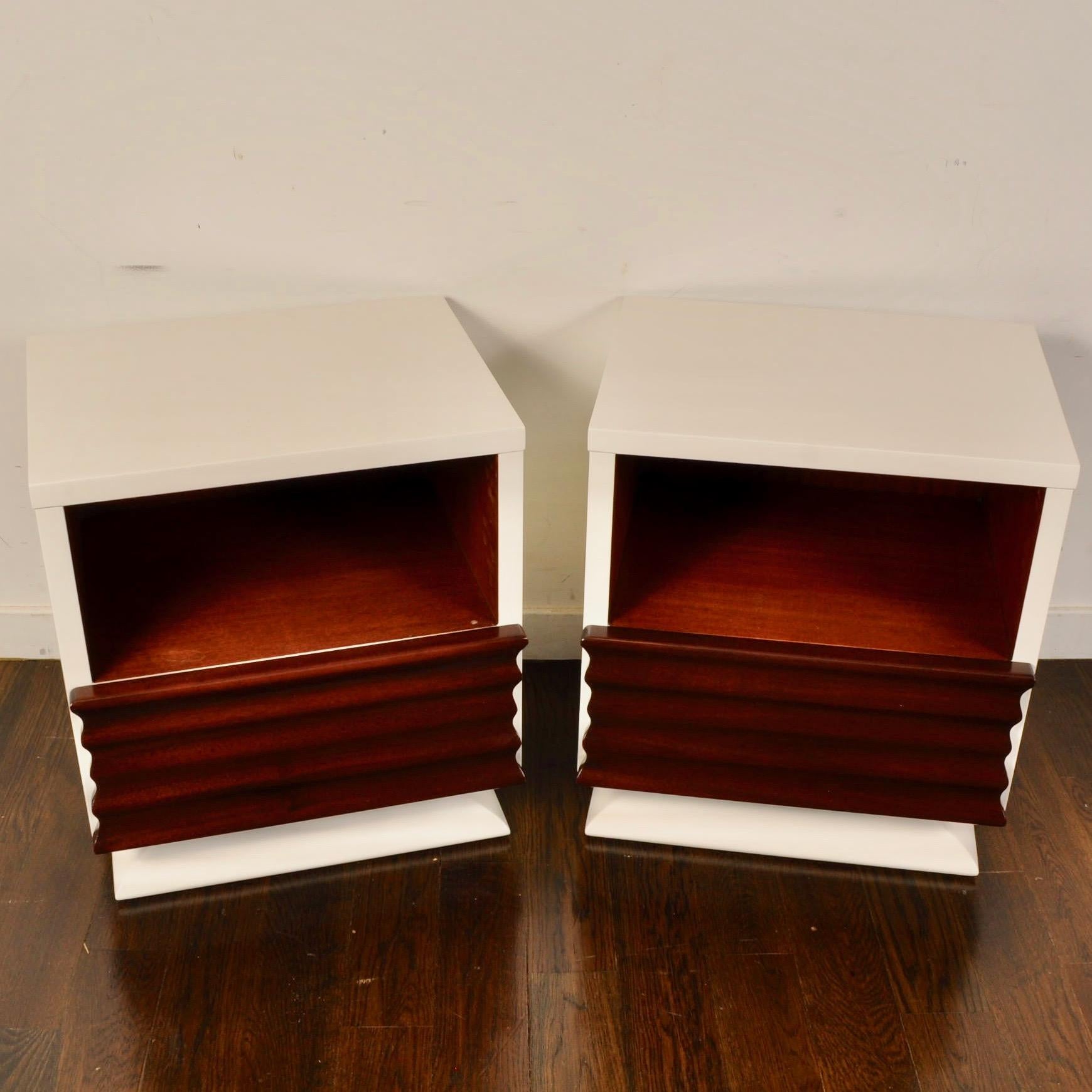 Nice sculptural front mahogany nightstands from the 1950s that have been updated with a white lacquer. Each piece features a deep cubby and a bottom drawer.