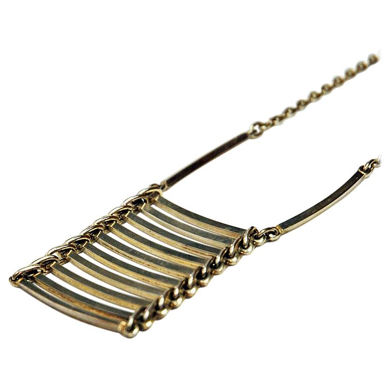 Wonderful pendant silver necklace Danish midcentury designer NE from in the 1960s, Denmark. With horizontal bars lying on top of each other like a ladder. Slightly curved. Good vintage condition.

Measures: Pendant width ca 4 cm., depth 0.2 cm.,