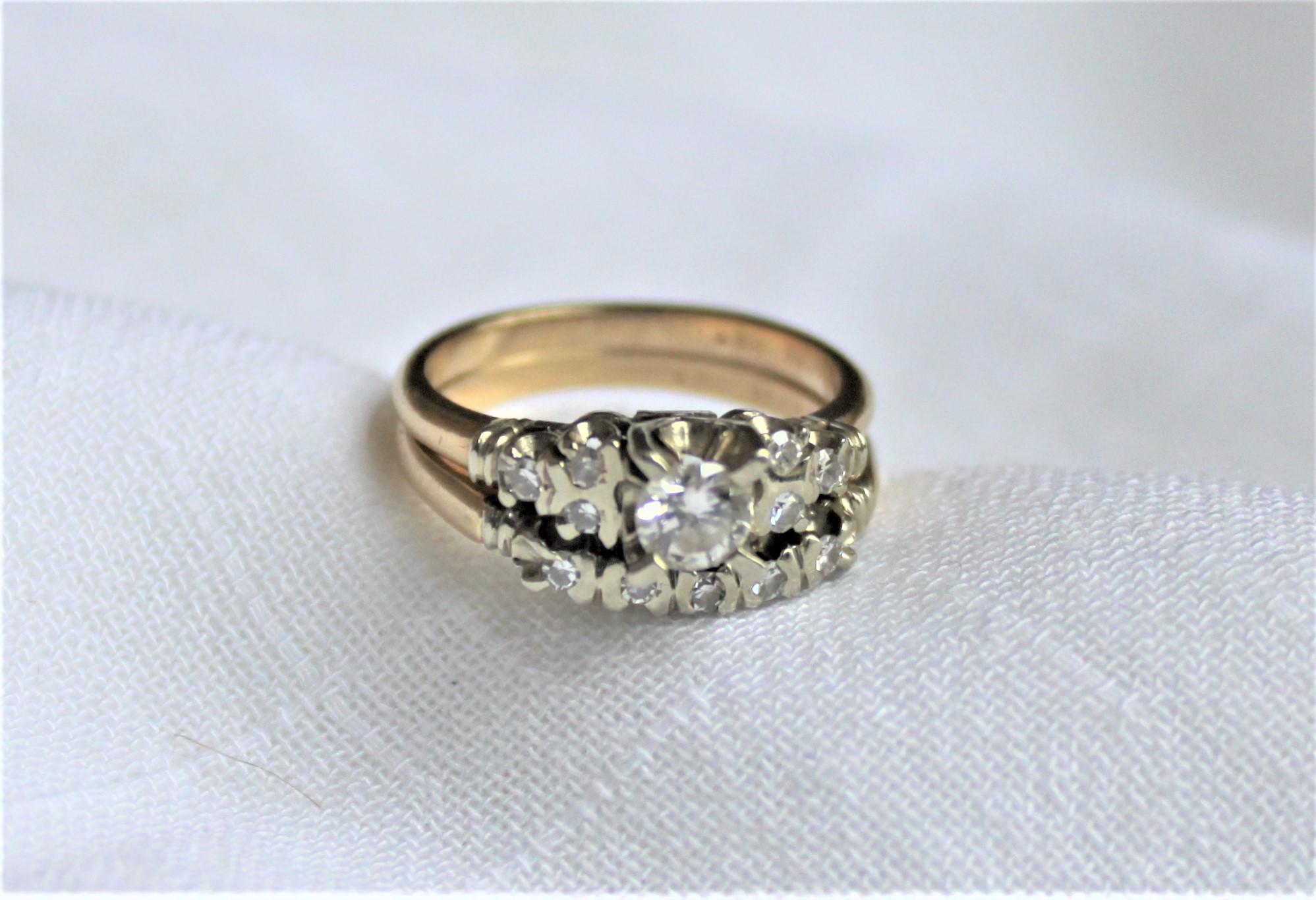 This ladies 14 karat yellow and white gold and diamond matching engagement ring and wedding band set was made during the 1960's, most likely in the United States. The engagement ring features one brilliant cut and prong set diamond with a clarity