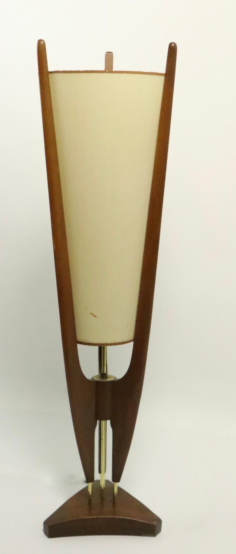 Dramatic midcentury table lamp designed by John Keal for Modeline. This stunning lamp features a tapering conical shade (original) which is supported by sculptural walnut struts on a triangular base. This example is in original, untouched condition,