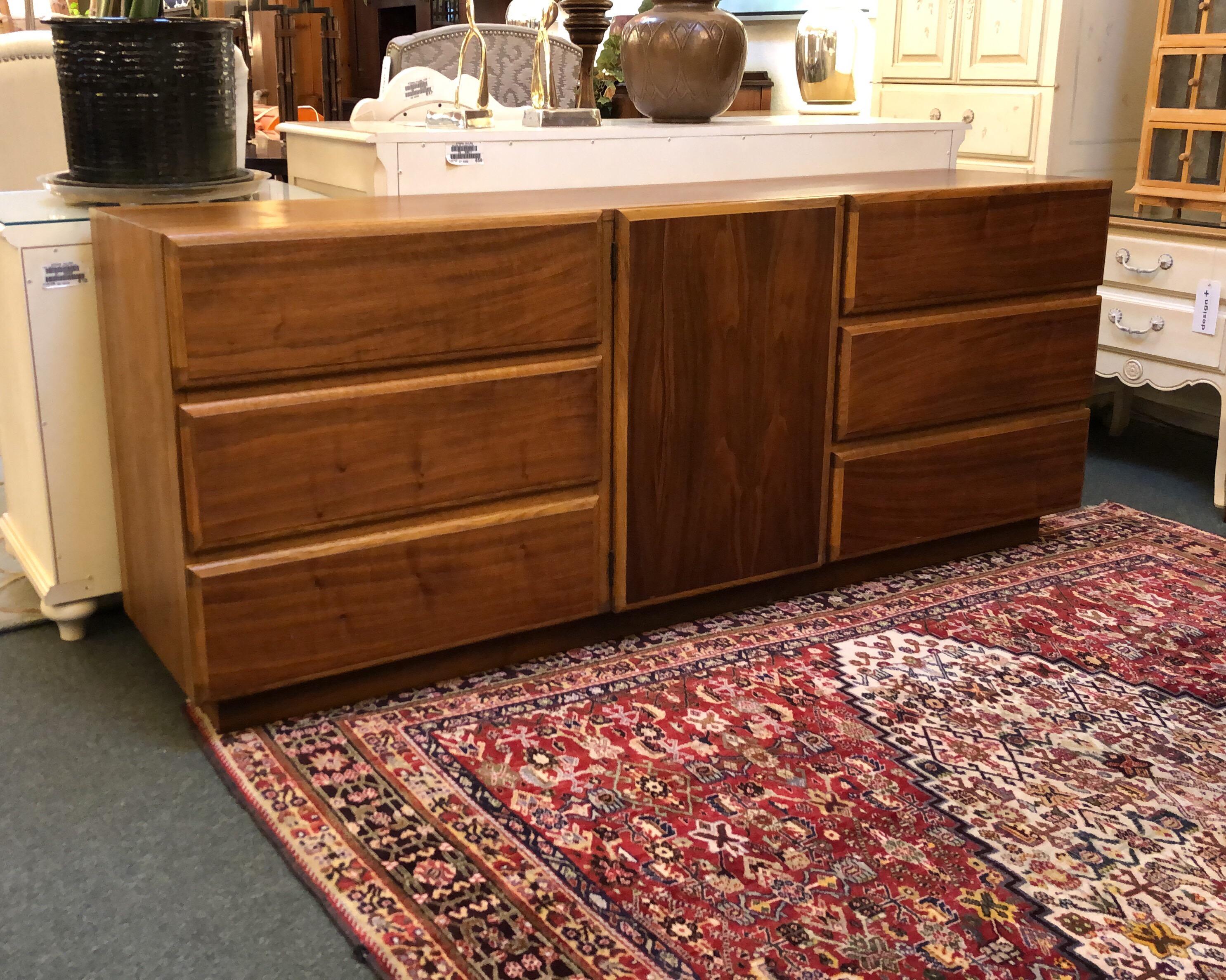 9-drawer from Lane Furniture. A midcentury beauty crafted in solid cherrywoods and veneers. The right hinge center door swings open to reveal three pullout drawers. Aged gracefully, an iconic design that fits in our modern day. Made in USA.