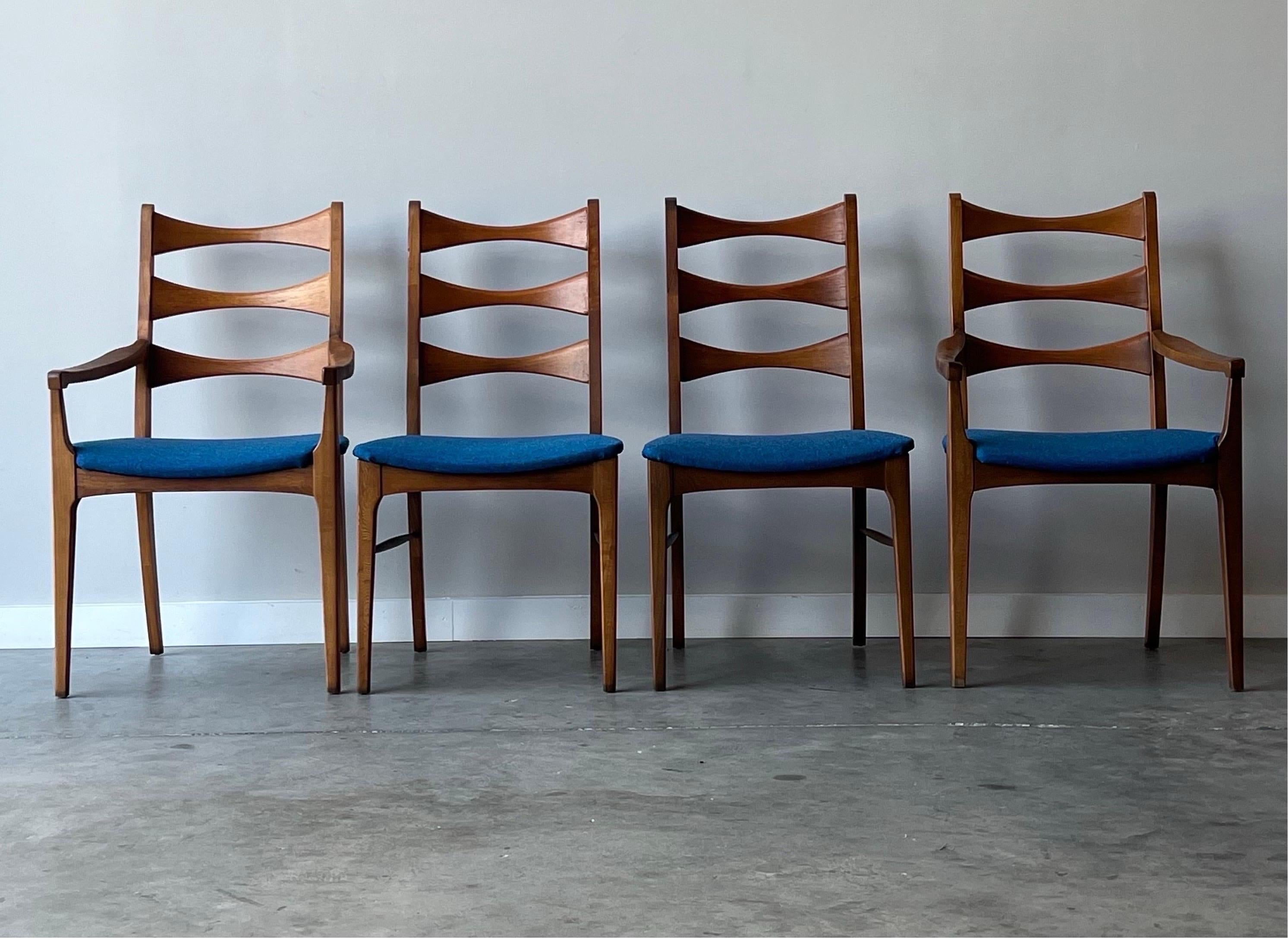 Set of four dining chairs by Lane Furniture. This set is a part of Lane’s coveted Rhythm collection. The classic “cat eye” shape aligns the back rest and spindles conjoin the front and back legs made from beautifully sculpted walnut. The set of four