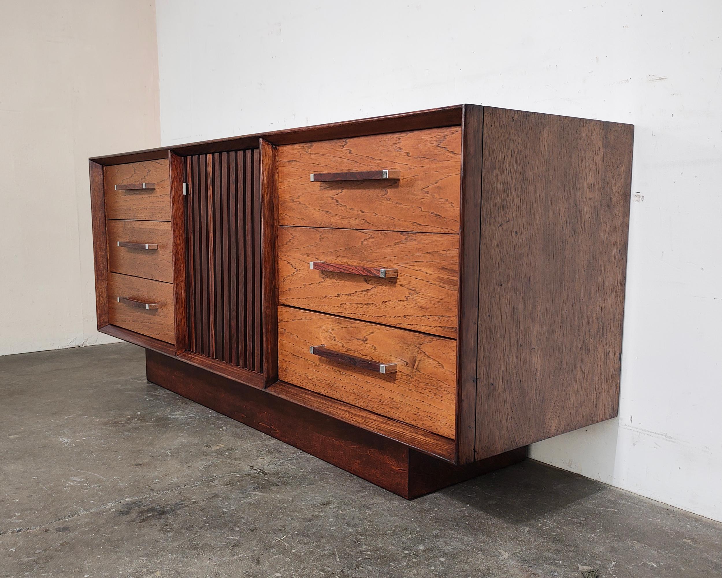 Mid-Century Modern rosewood and pecan wood lowboy 'Tower Suite' dresser by Lane. Six drawers on each side with contrasting rosewood and chrome pulls. Rosewood slat center door contains three smaller drawers inside. Top features rosewood design