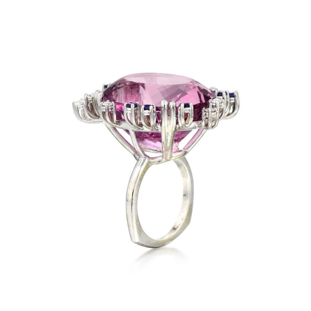 Stunning 1950s Retro 14k Gold 47.8 ct Kunzite Gemstone, Diamond and Sapphire Large Statement Ring

Impressive large cocktail ring crafted in 14K white gold (tested); 
set with an oval-cut kunzite weighing 46.98 carats; 
complemented by 11 round-cut