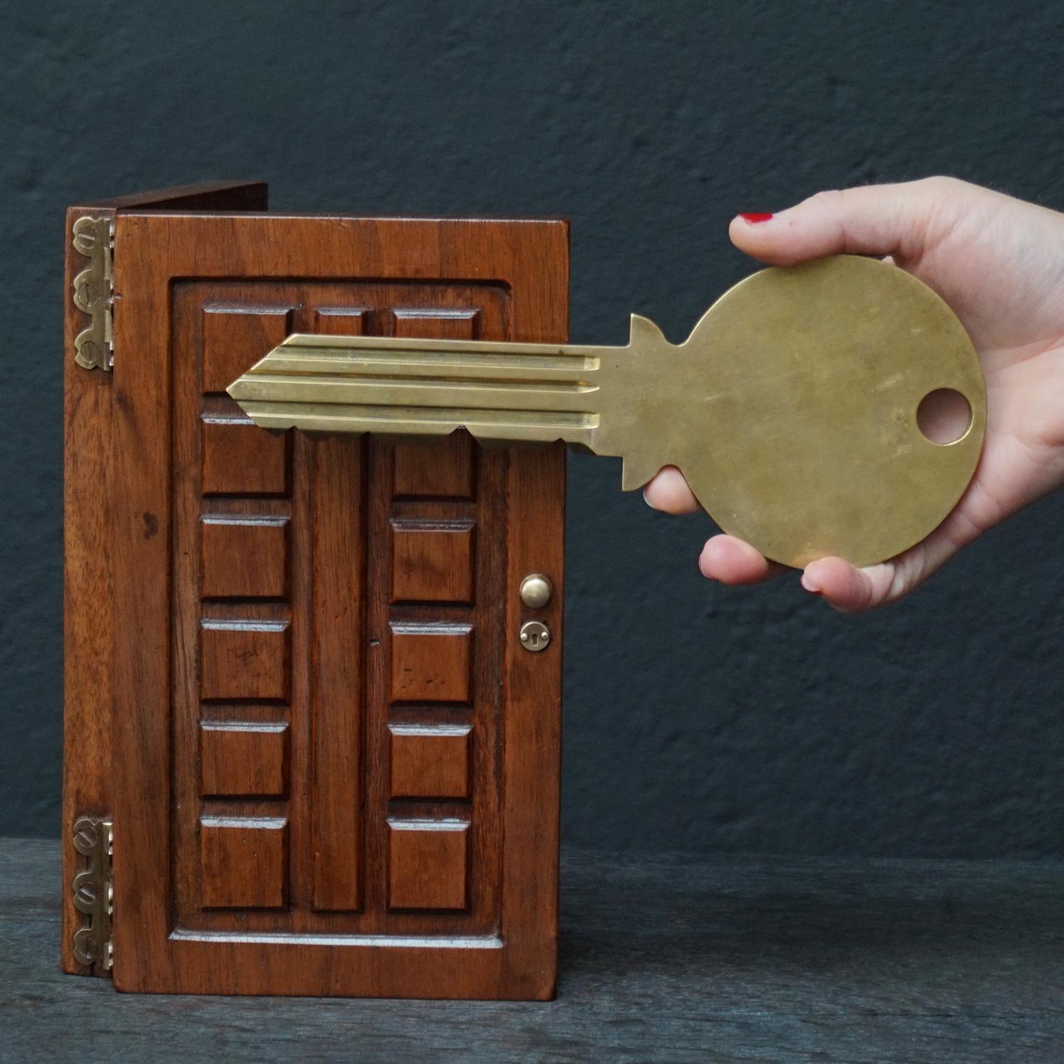 Very pretty and heavy vintage brass 'front door' key in a box made of walnut wood, shaped as a flat door with little brass hinges, little fake keyhole and doorknob.
I have no idea what or who this novelty object was originally made for.
But now it