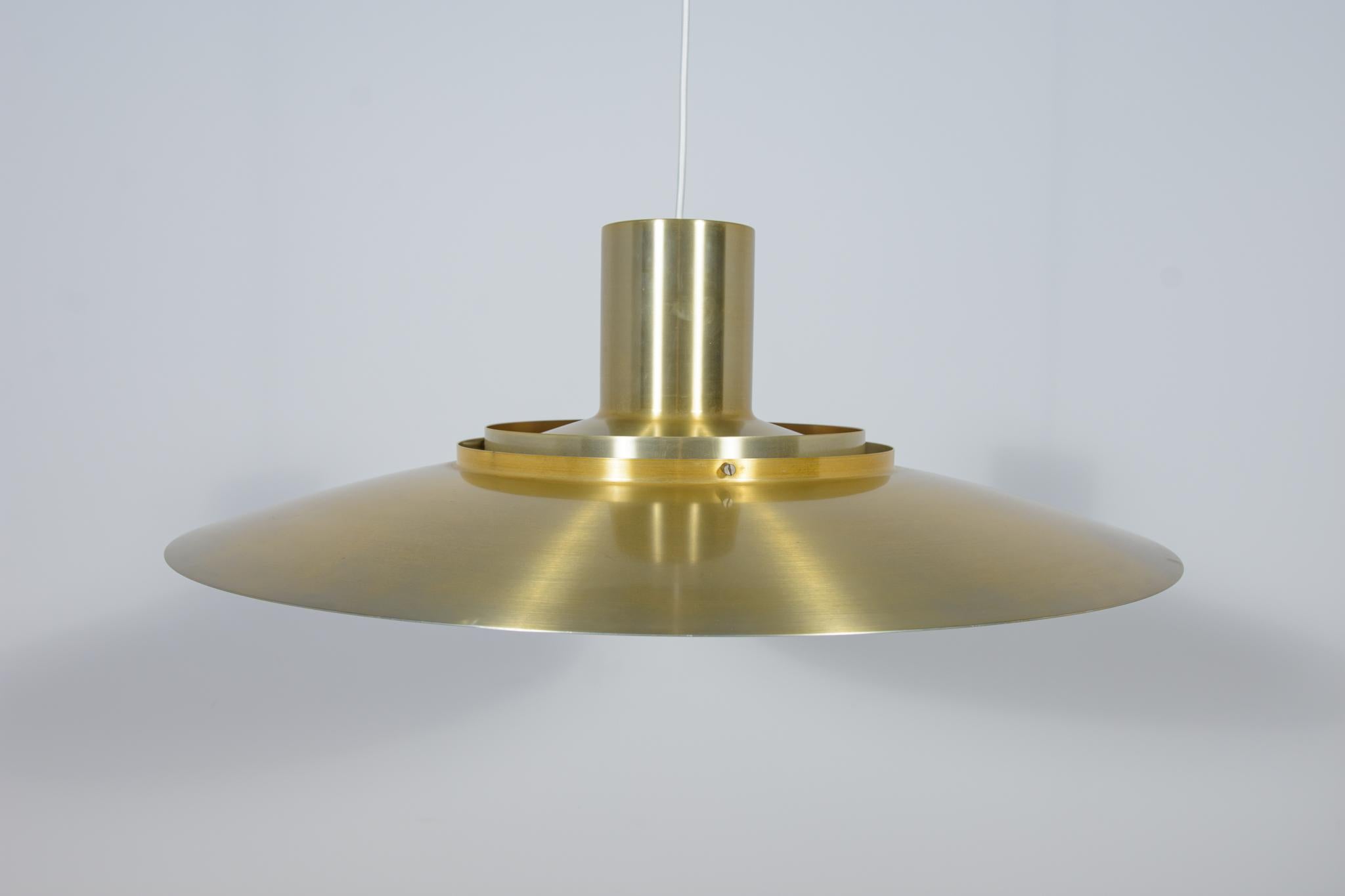 Aluminium Pendant lamp  covered with brass consisting of five levels, equipped with one E27 socket with a power of up to 200 watts. Designed by Preben Fabricius and Jørgen Kastholm for Nordisk Solar Compagni in 1964. It is the largest example ever