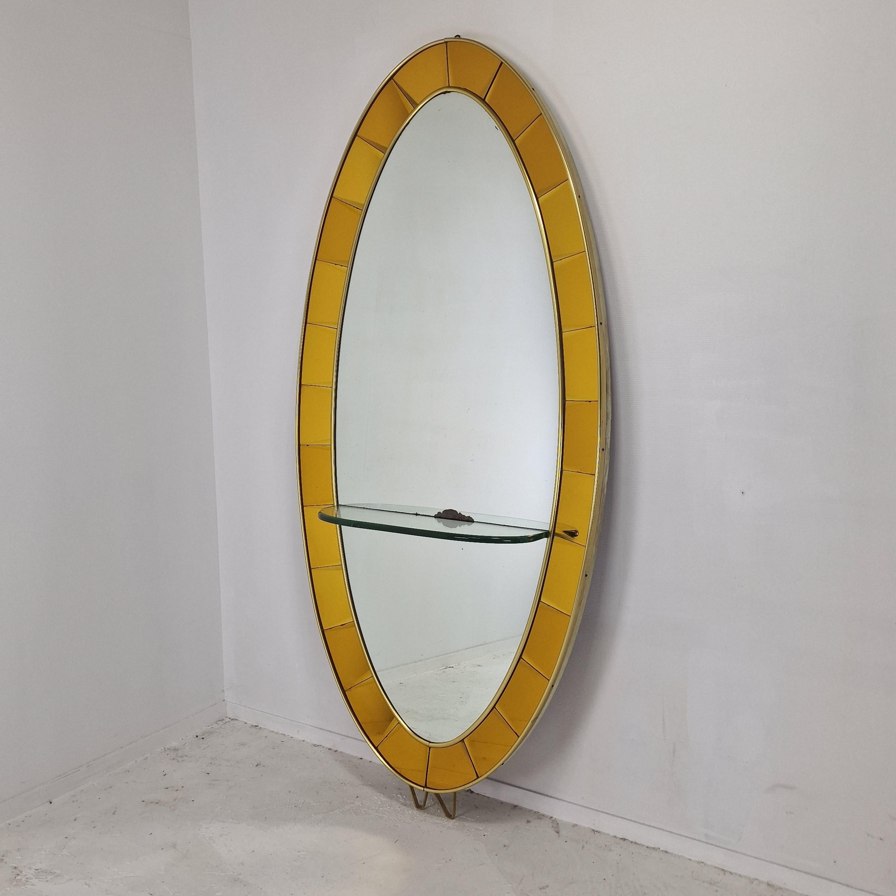 Magnificent and very large floor mirror, original from the 50's.
Fabricated by the Italian company Cristal Art.

Elegant oval shaped with a thick bevelled crystal console table.
Beautiful gold yellow crystal glass and a brass frame. 
The mirror