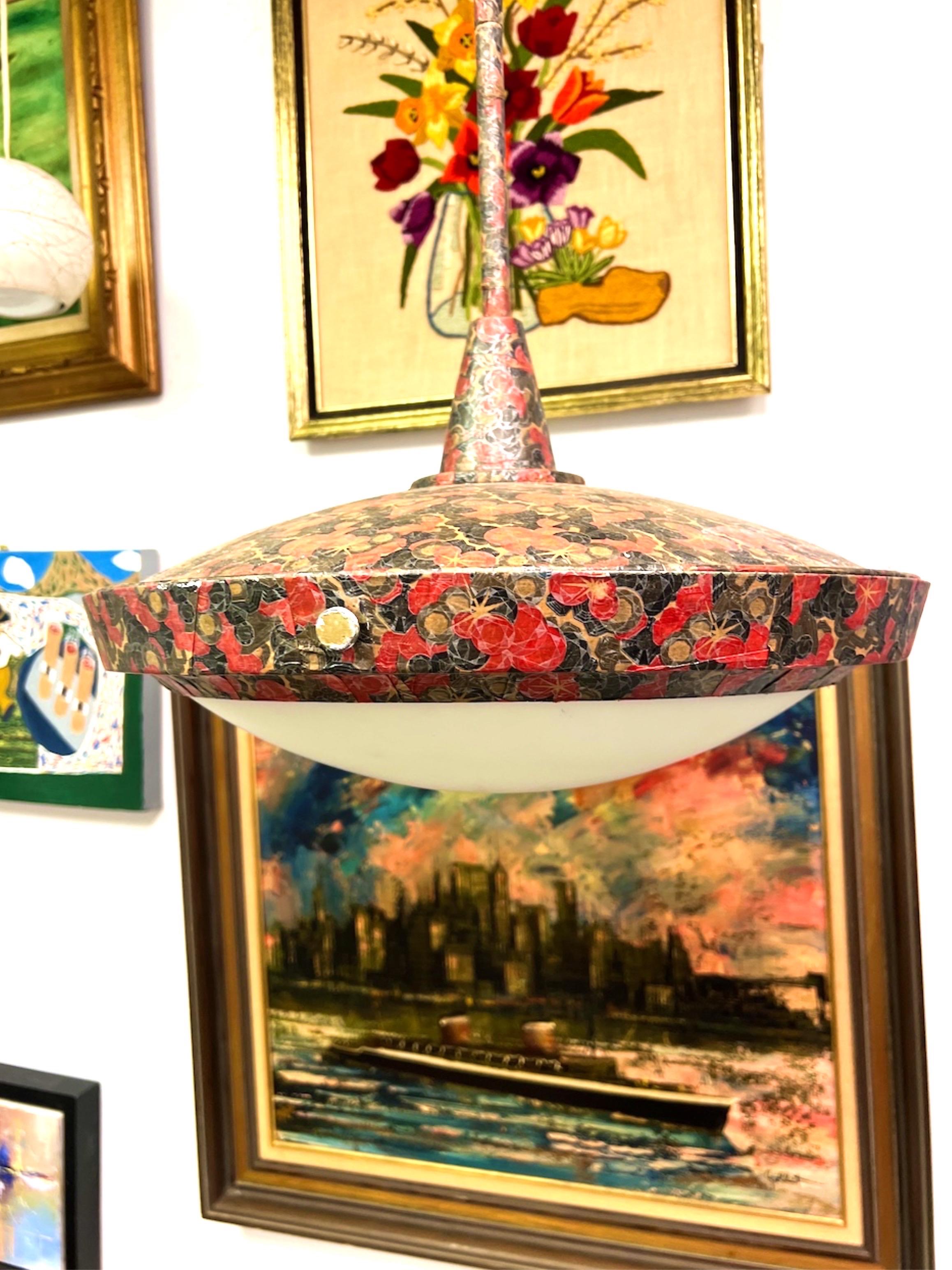 Esta fabulosa lámpara colgante grande con forma de platillo de mediados de siglo ha sido decoupageada con un papel de arroz japonés de flores rojas. Los herrajes de latón de los laterales sujetan el gran cristal satinado. Las medidas son desde la